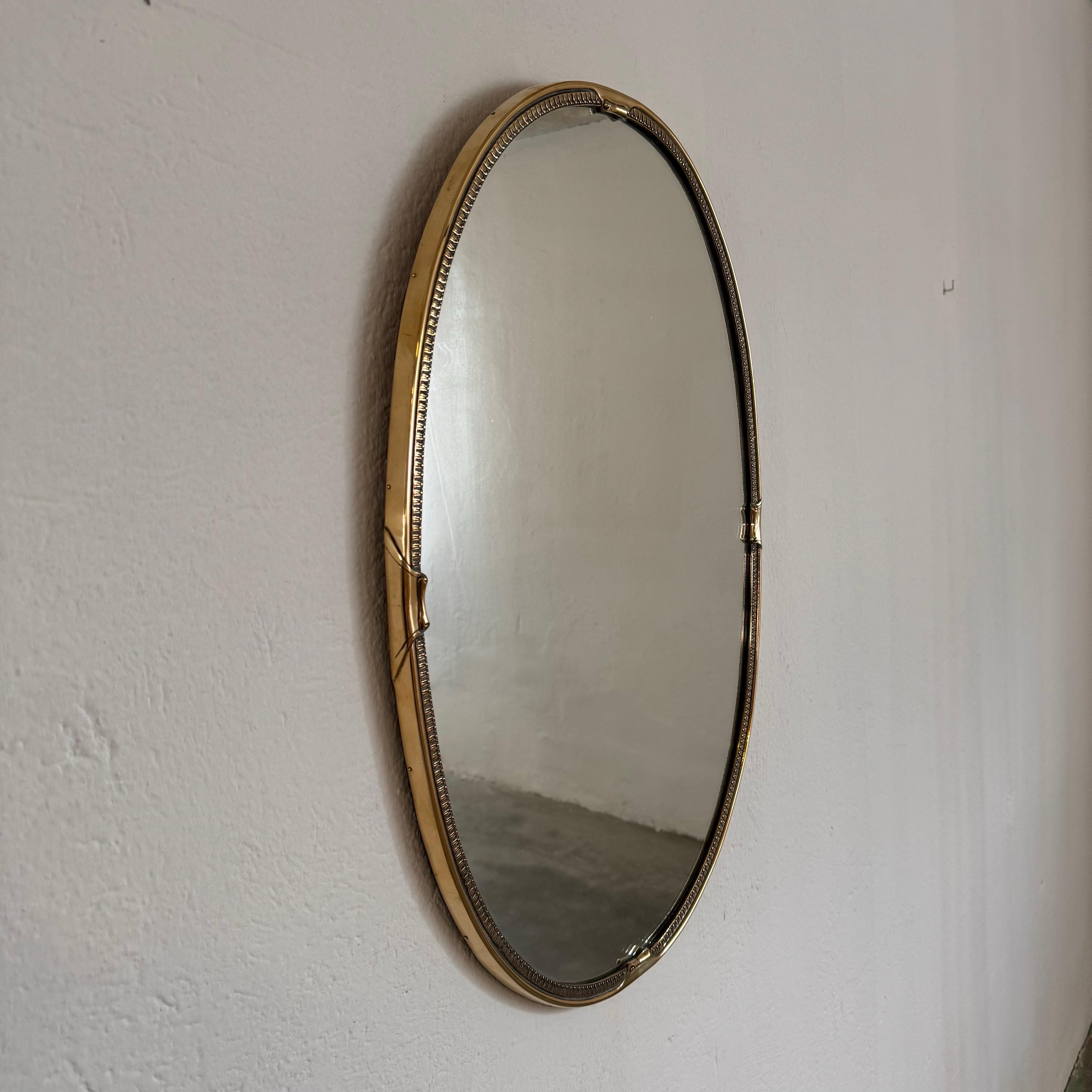 Step into the timeless elegance of mid-century Italian design with this exquisite brass mirror, reminiscent of the iconic style championed by the legendary Gio Ponti. Crafted in the 1950s, this mirror hails from a prestigious goldsmith in the heart
