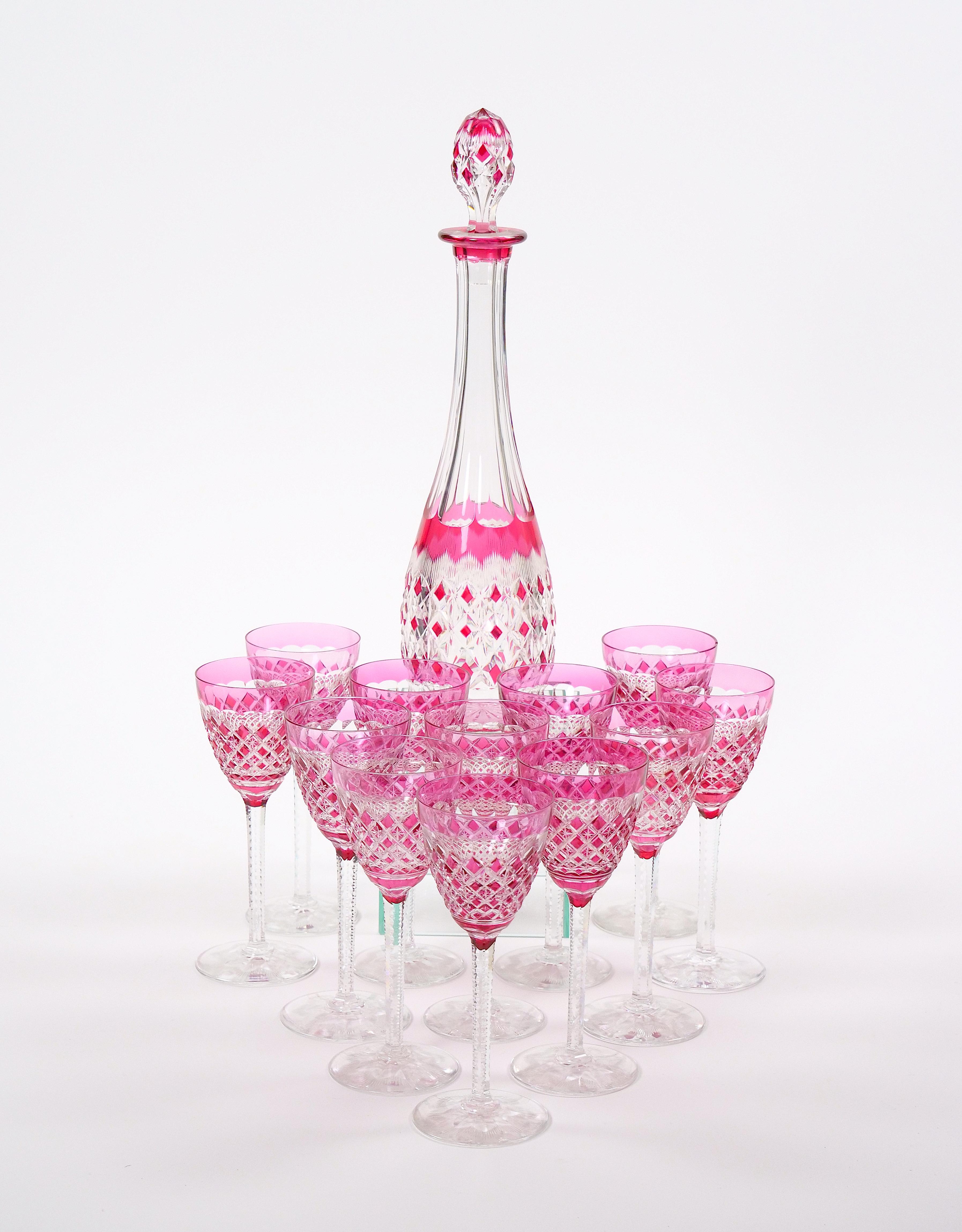 This rare and elegant 19th-century French Baccarat crystal wine set, crafted in a light ruby pink cranberry color, is a masterpiece of refined luxury and craftsmanship. The set includes ten beautifully designed wine glasses and a matching wine