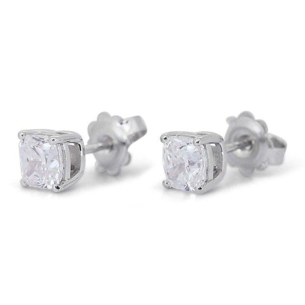 Embrace sophistication with these captivating 2 carat cushion diamond earrings, meticulously crafted in gleaming 18K white gold. Each earring features a mesmerizing cushion cut diamond, boasting an exceptional D-E near-colorless range and VS1-VS2