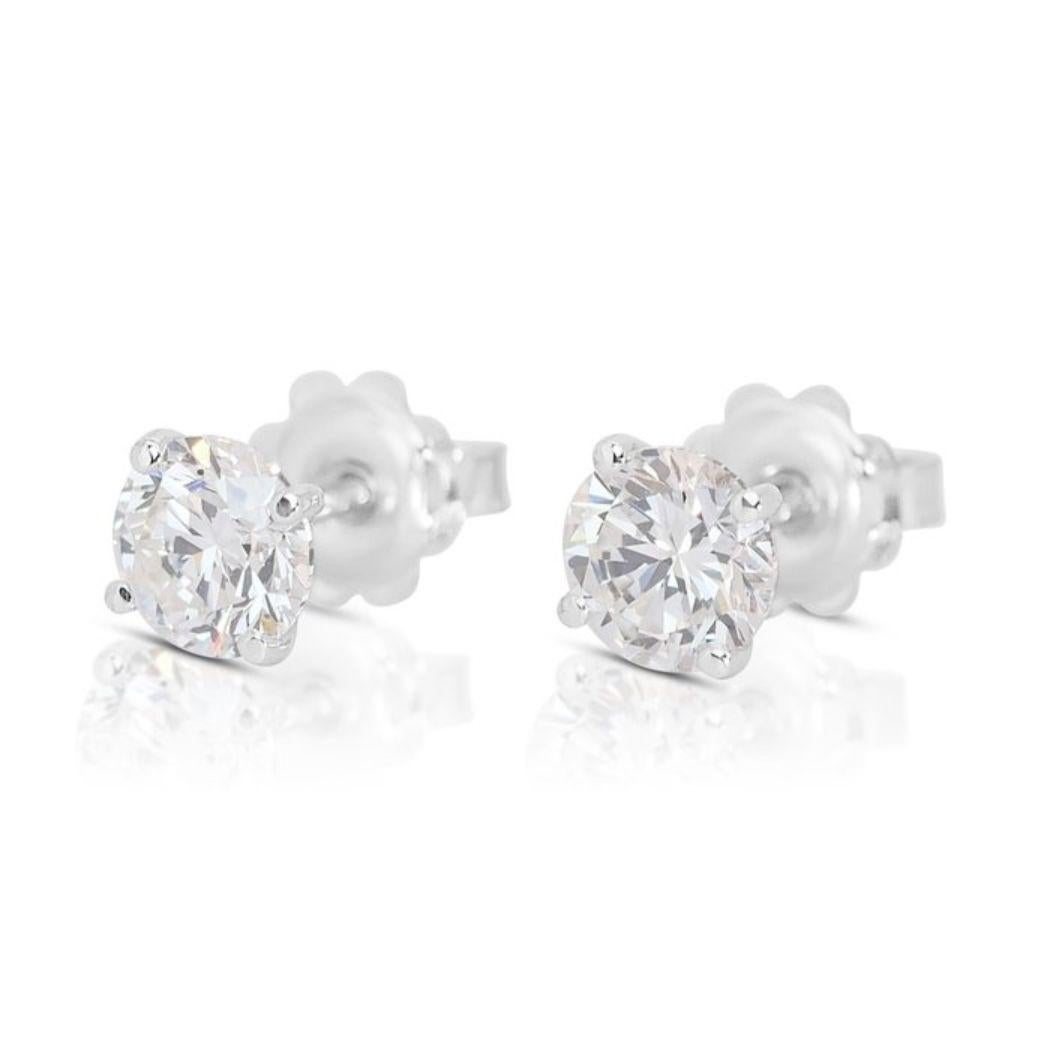 These exquisite earrings boast two dazzling round brilliant-cut diamond main stones, weighing an impressive 2.00 carats. With their F-G color grade, these diamonds exhibit a near-colorless hue, radiating brilliance and sophistication. Their