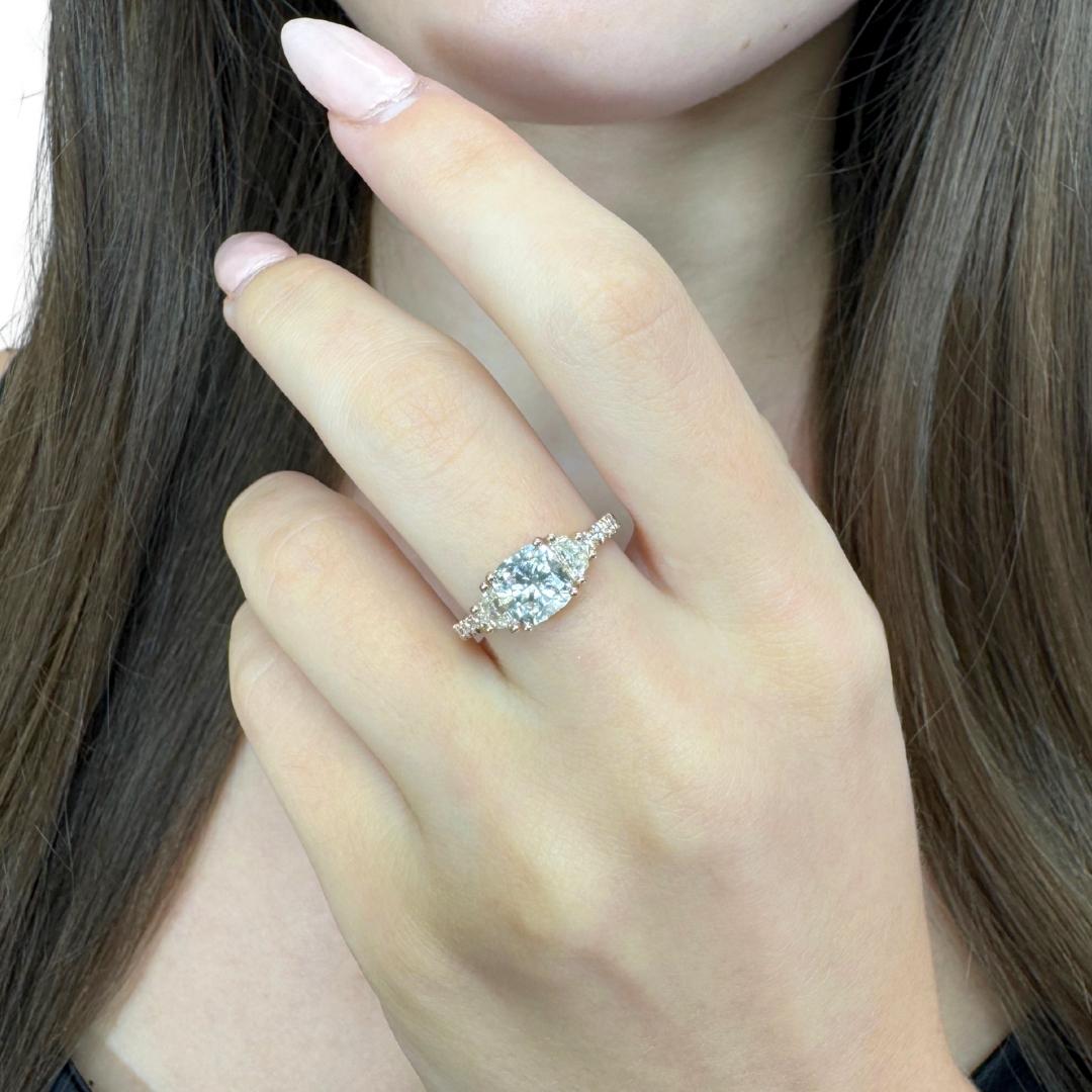 Squisito anello a tre pietre con 2,00ct di diamanti in oro rosa 18k - certificato IGI

Questo incantevole anello in oro rosa 18 ct. mette in mostra un diamante con taglio a cuscino da 1,50 ct. che irradia eleganza con il suo ottimo taglio. Su
