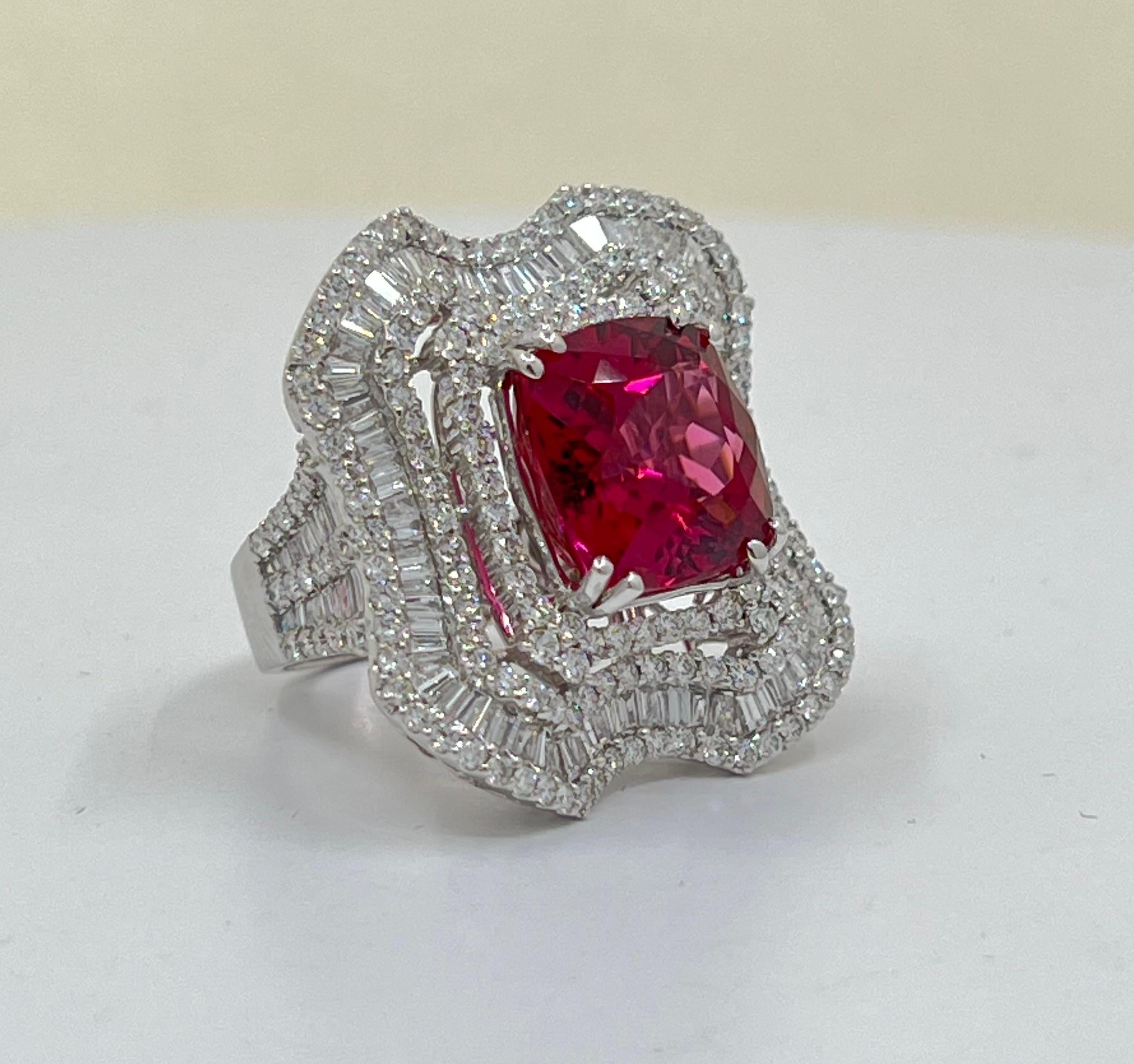 Absolutely exquisite, large cushion cut vivid pink rubellite or rubelite, is talon prong set in 18 karat white gold and surrounded by prong-set baguette and round brilliant diamonds in a timeless and very elegant cocktail ring setting. The center