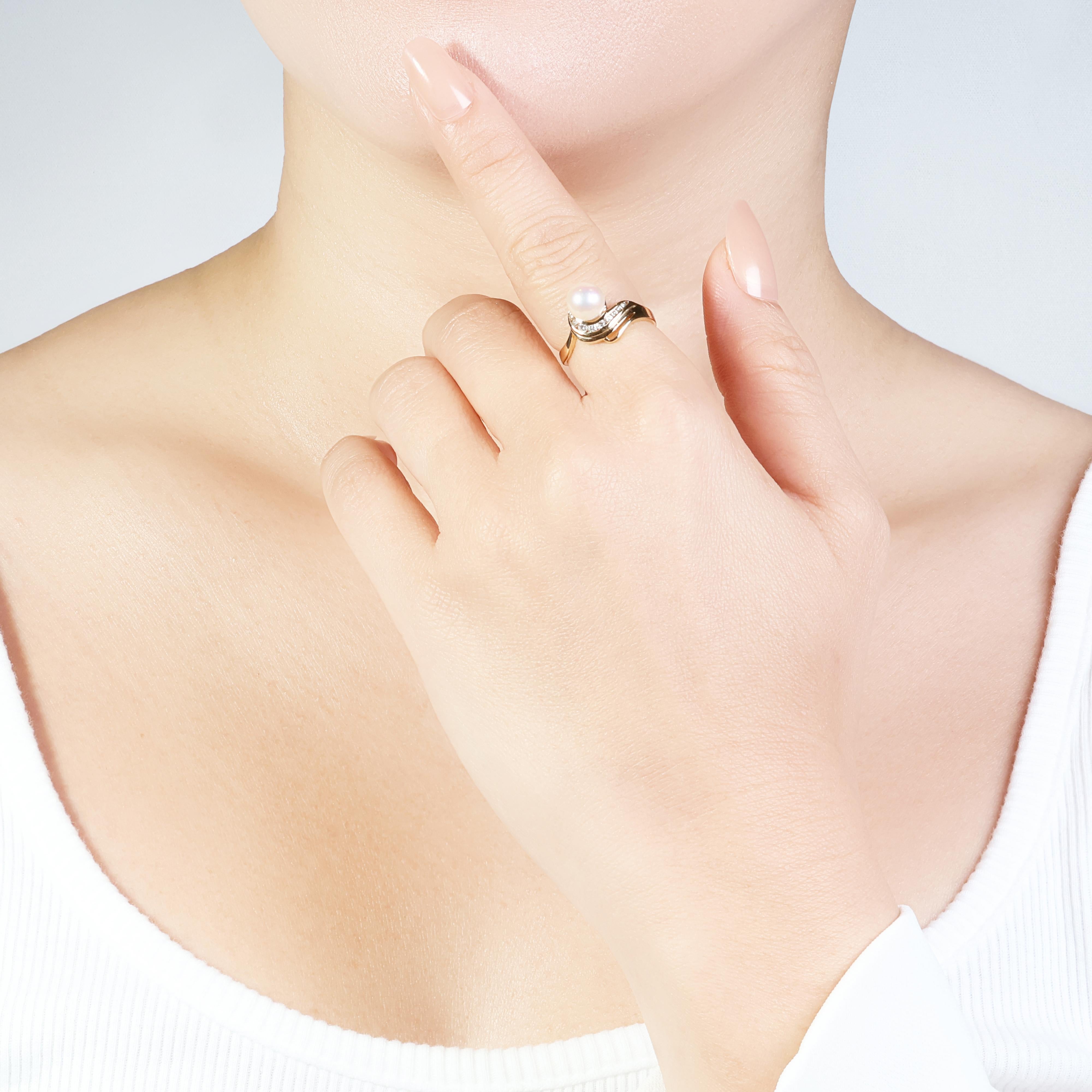 This elegant 18k yellow gold ring features a beautiful 6.75mm round brilliant cut Akoya pearl with a white color. The pearl is surrounded by 9 sparkling round brilliant cut diamonds, each weighing 0.13ct and with a G color and VS clarity. The ring
