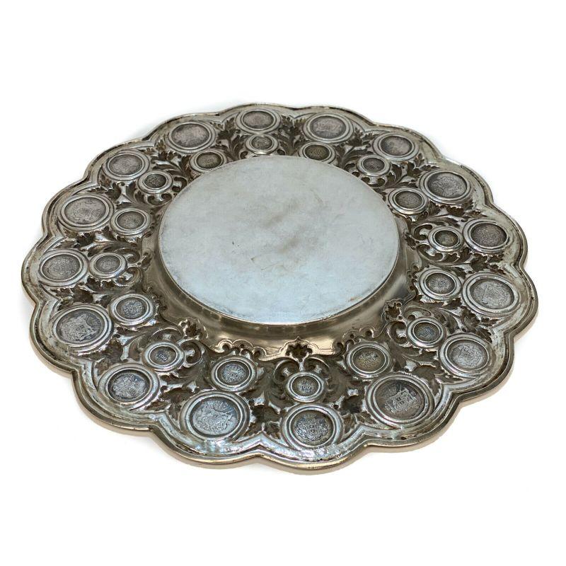 Exquisite 833 Porto silver coin mounted centerpiece tray charger, early 20th century.

32 Portuguese coins inset around the hand chased foliate scroll and scalloped rim. Porto silver hallmark to the edge.

Additional Information:
Age: 19th