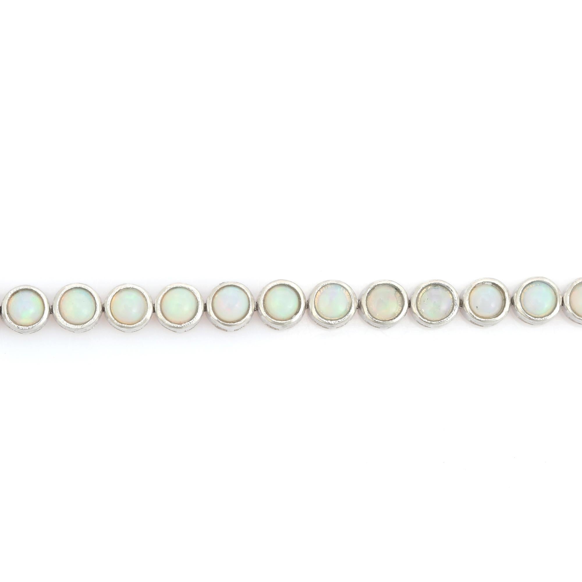 Dieses äthiopische Opal-Cabochon-Tennisarmband ist ein exquisites äthiopisches Opal-Tennisarmband, das in sorgfältiger Handarbeit aus 925er Sterlingsilber gefertigt wurde. Jeder runde, in eine Lünette gefasste Opal leuchtet in einem faszinierenden