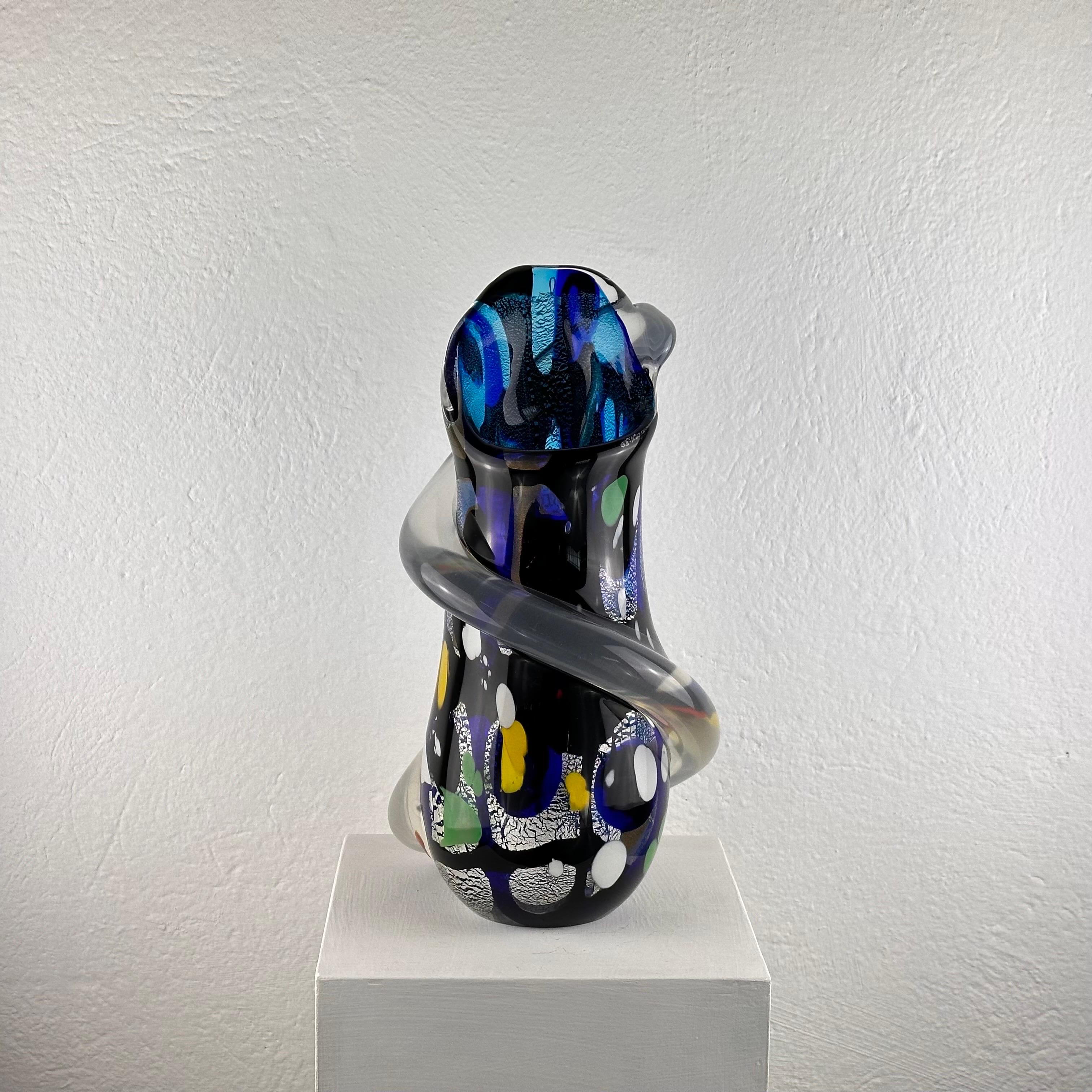 This captivating Murano glass vase, crafted by the skilled hands of renowned artisan Stefano Toso in the 1970s, is a testament to the ingenuity and artistry of Italian glassmaking. Standing as a timeless symbol of creativity, this piece embodies the