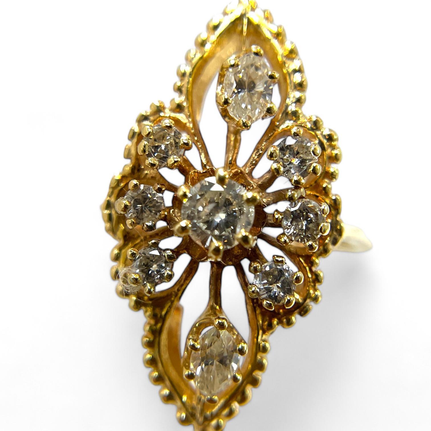 This stunning antique gold ring showcases a beautifully intricate marquise-shaped design, adorned with sparkling diamonds that create a captivating floral pattern. The ring’s detailed craftsmanship features an elegant openwork lattice, enhancing its