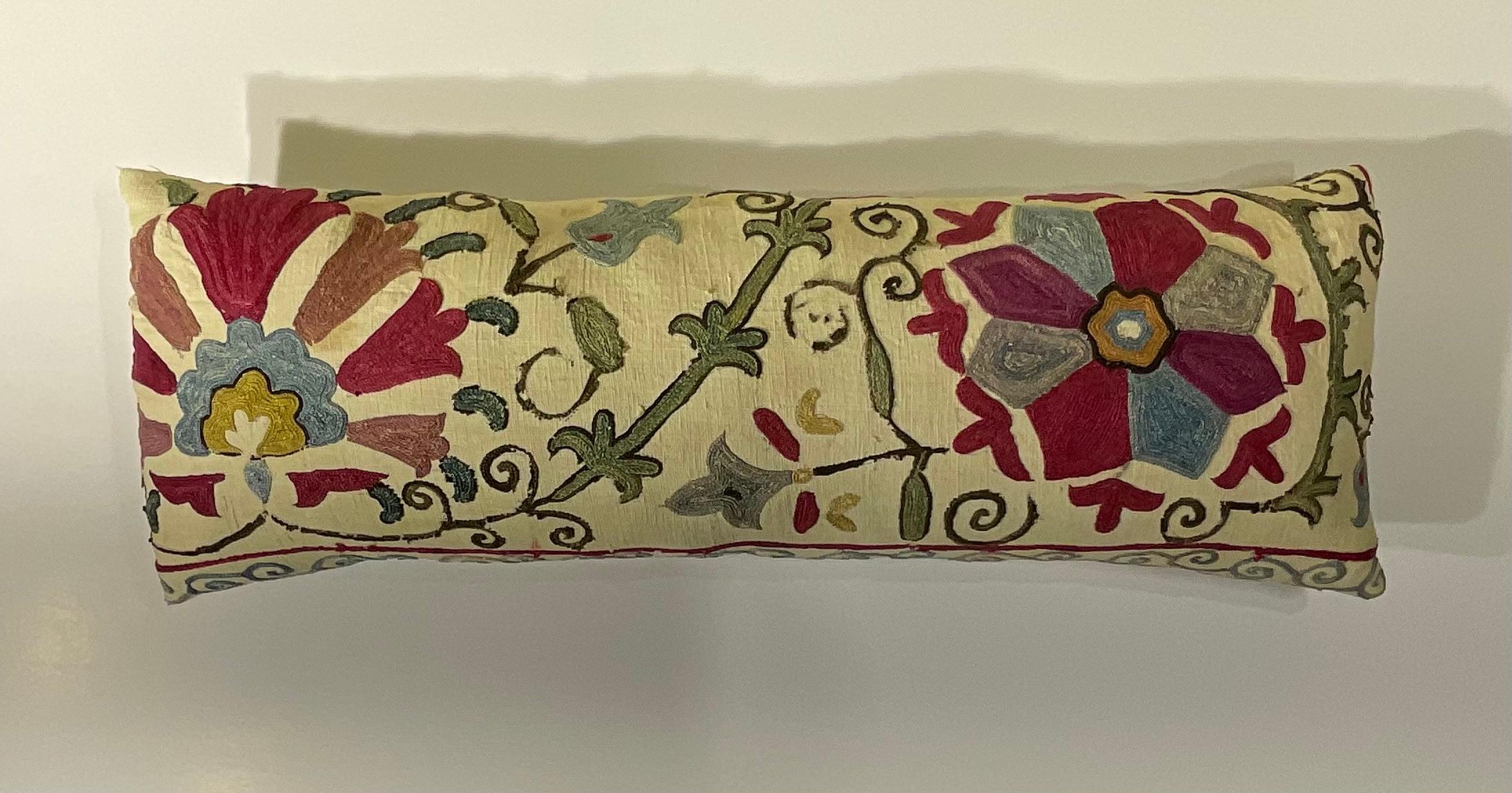 Magnifique coussin ancien en textile Suzani, brodé à la main avec des fils de soie vibrants sur une base de coton doux, cette pièce est plus qu'un simple coussin - c'est un fragment captivant de l'héritage de l'Asie centrale, prêt à apporter une