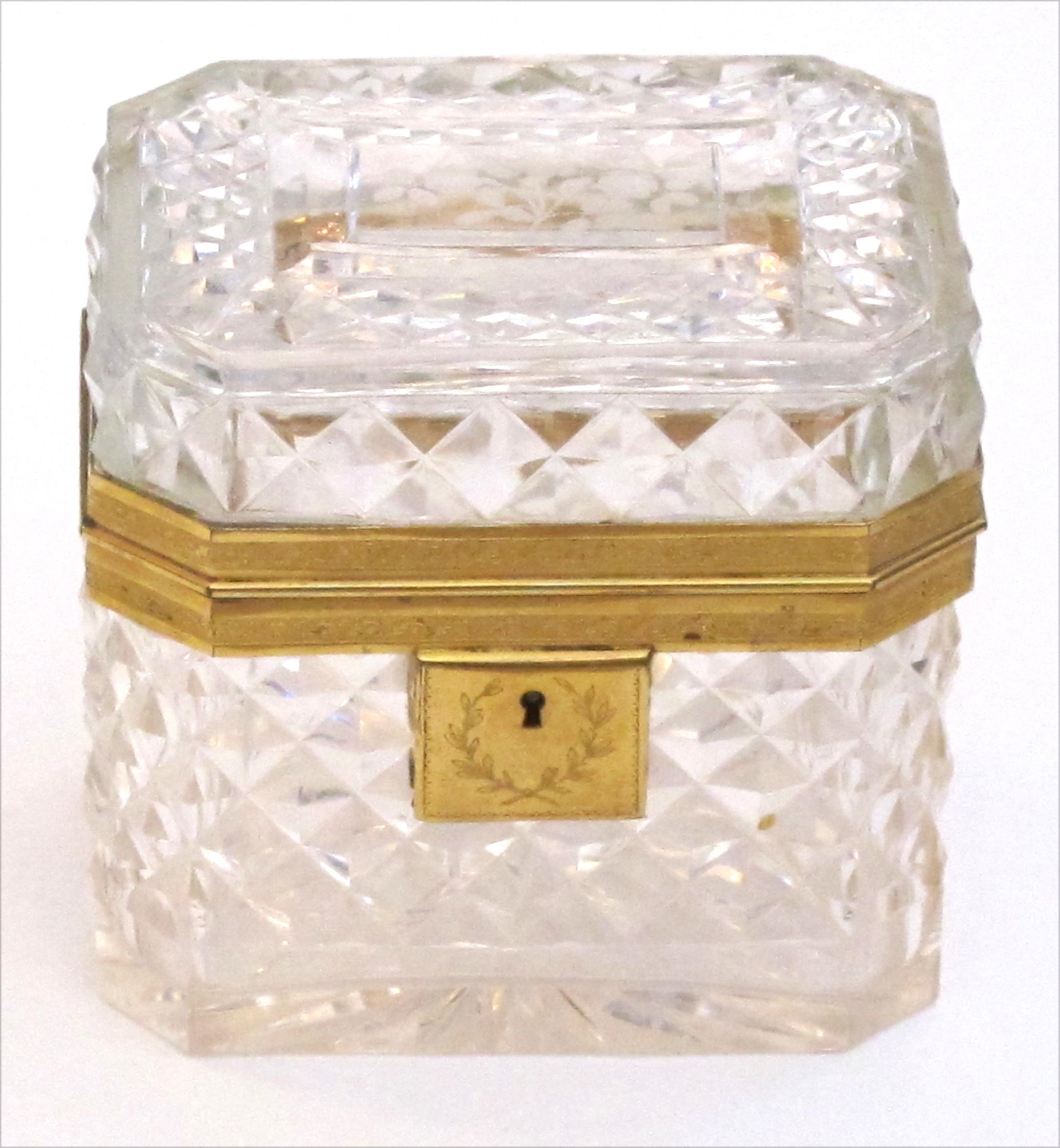 Of rectangular shape with canted corners this cut-crystal trinket box with a hinged lid; adorned overall with finely chased doré bronze mounts; a jewel of a box of first quality.