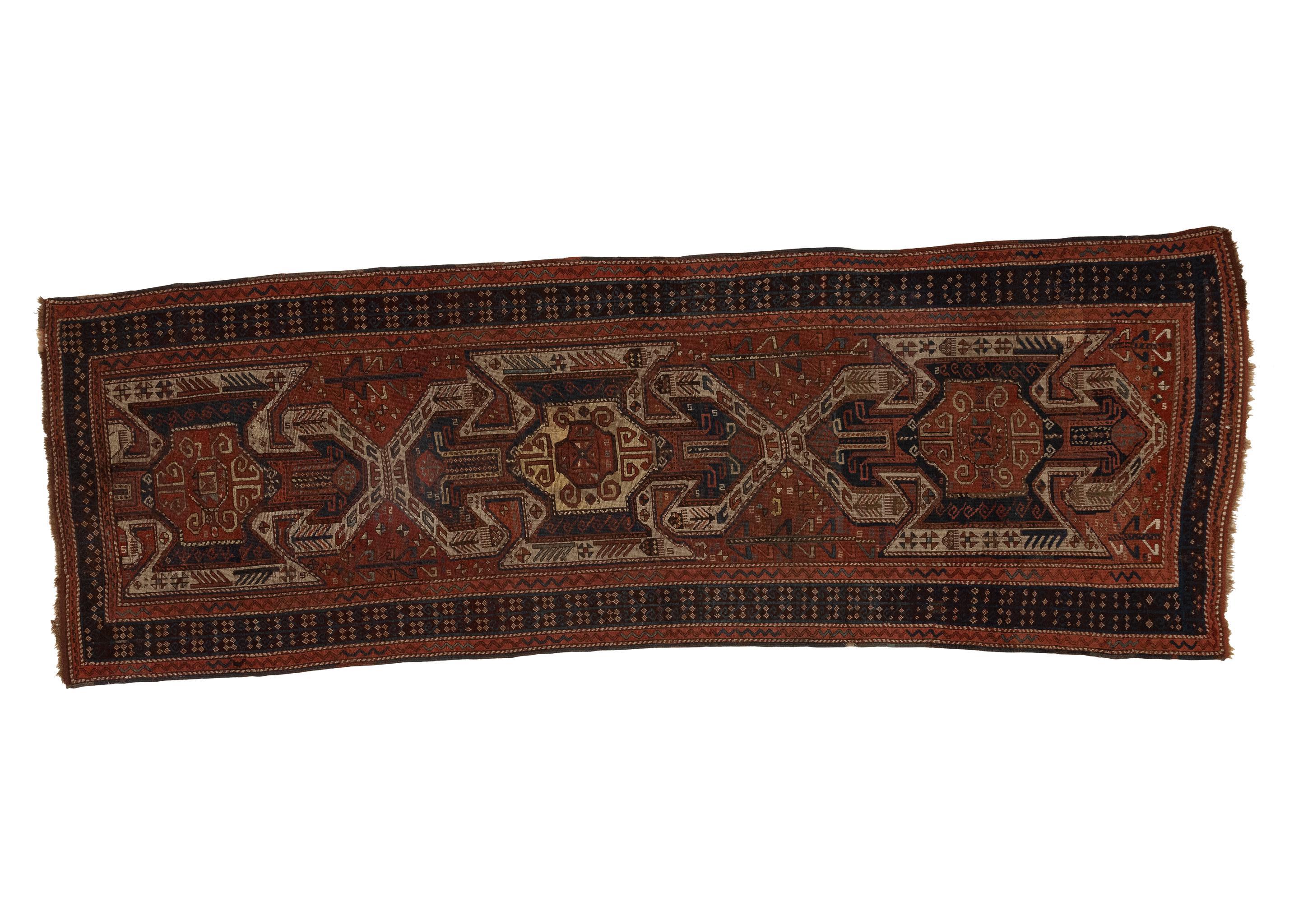 This antique Caucasian rug from the 1880s showcases a captivating blend of burnt orange and black hues, adorned with a traditional design. Measuring 4x12, this rug is a testament to the artistry and craftsmanship of the Caucasian region during the