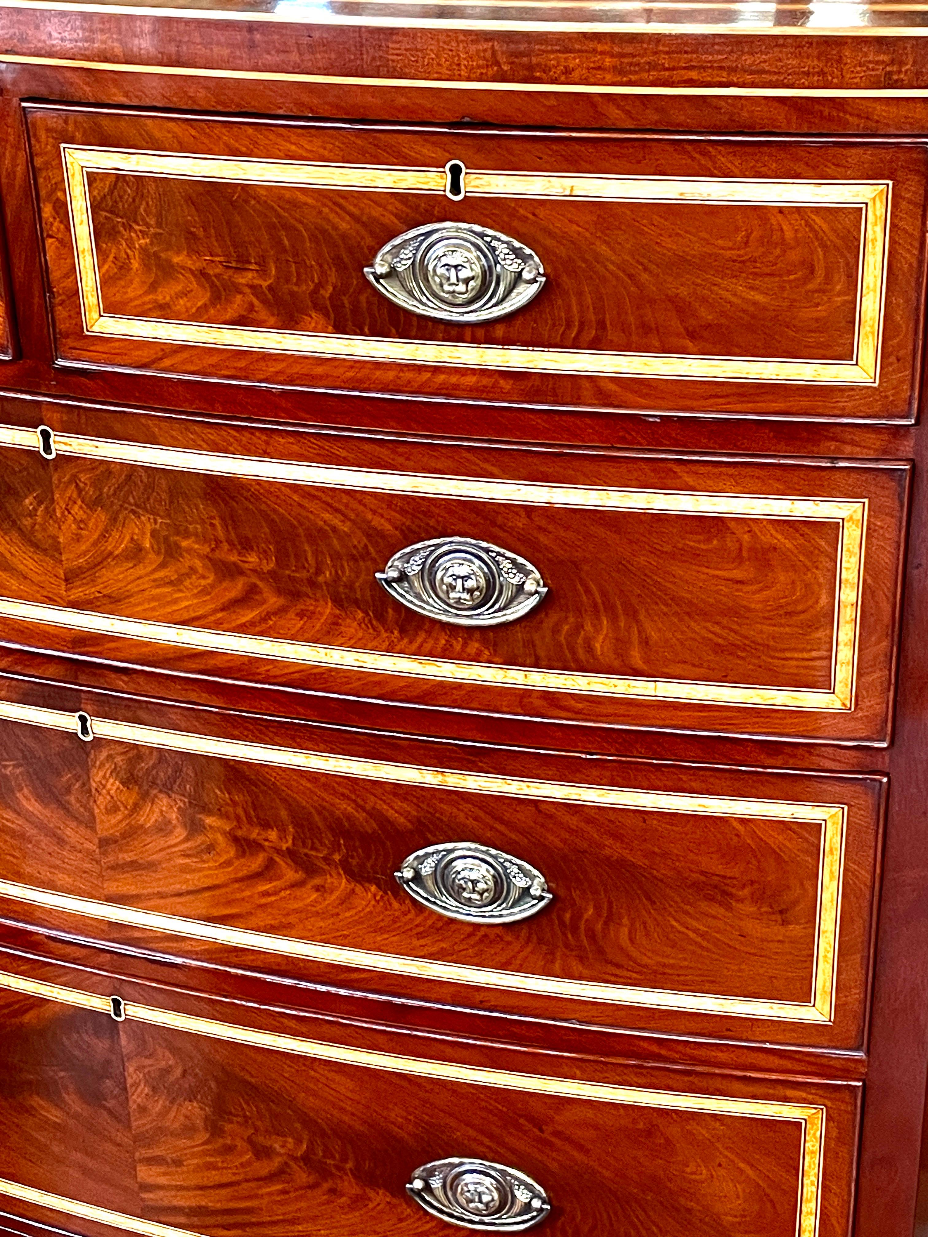A magnificent and useful Large Antique English Geo. IV period Hepplewhite style satinwood and rosewood inlaid bookmatched flame or crotch mahogany Bowfront two short over three long drawers with handsome oval brasses (likely later replacements but