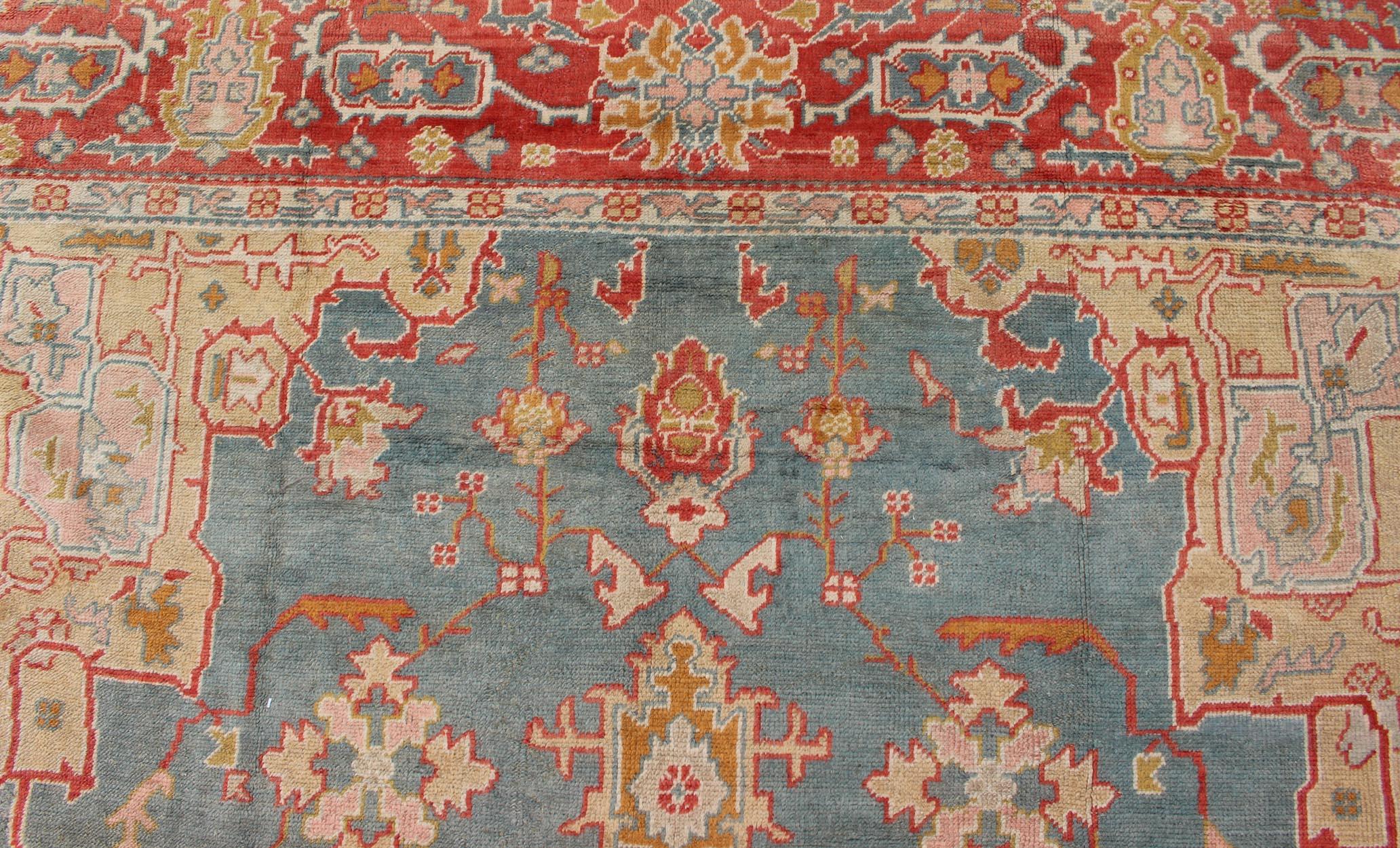 Wool Antique Turkish Oushak Rug On A Blue Background and Orange-Red Color Border For Sale