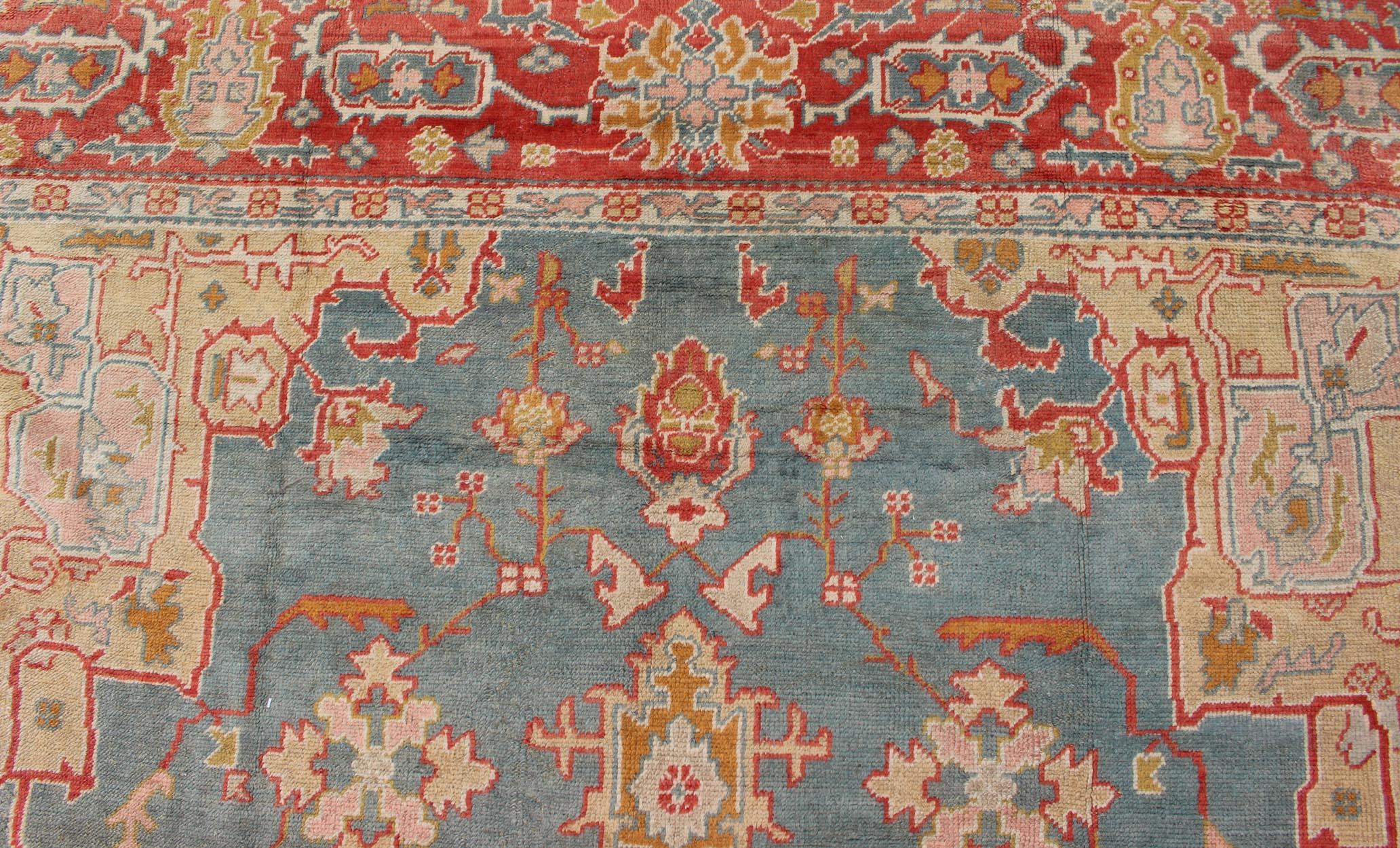 Wool  Antique Turkish Oushak Rug On A Blue Background and Orange-Red Color Border For Sale