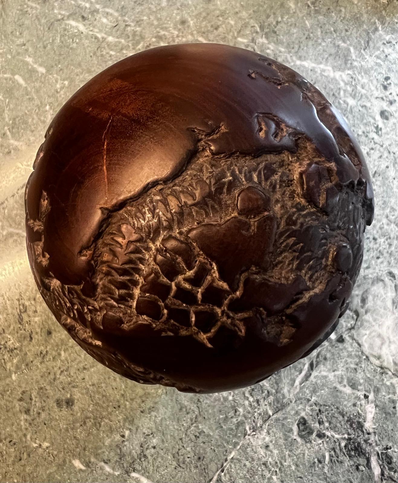 A wonderful Art Deco World Globe is hand carved out of noble dark brown ebony wood and consists of two parts. Put together it has an oval form with perfectly and precisely carved continental map on it. The Globe is rested on a brown marble block.