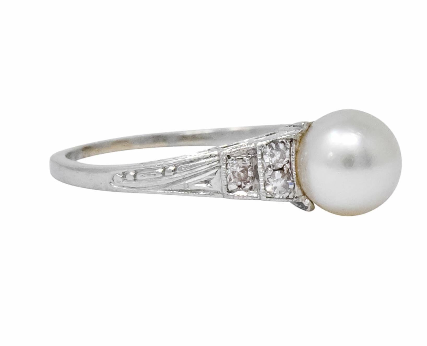 Centering a natural pearl measuring approximately 6.0 mm, white body color, rose overtone, with very good to excellent surface quality and luster

Flanked by single cut diamonds, weighing approximately 0.15 carat total, eye-clean and white

With