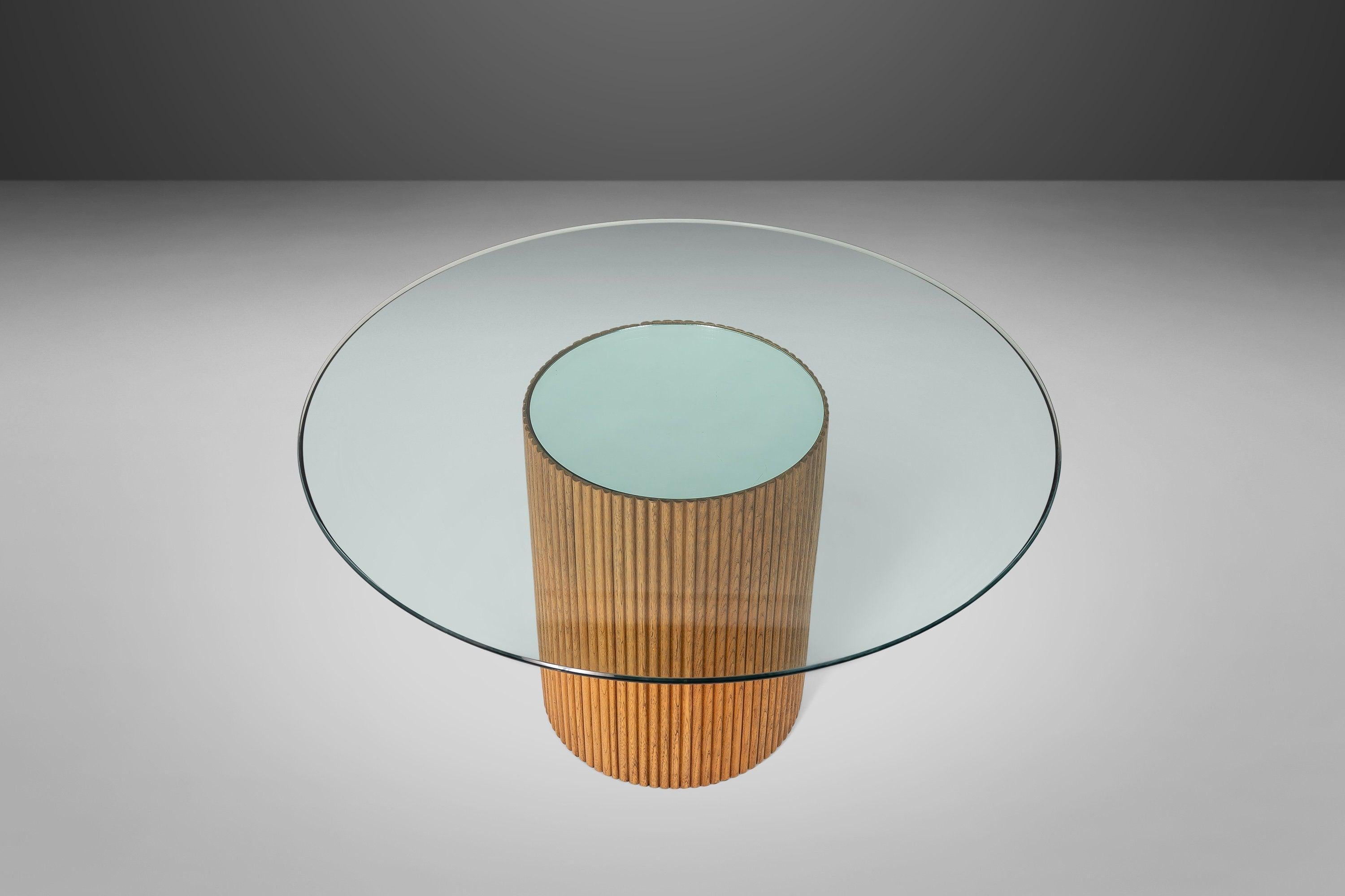 Truly an eye-caching dining table. A bamboo inspired slatted cylindrical base supports a round beveled glass dining table. The top of the base has a mirrored detailing which can be included or removed depending on your personal preference and design