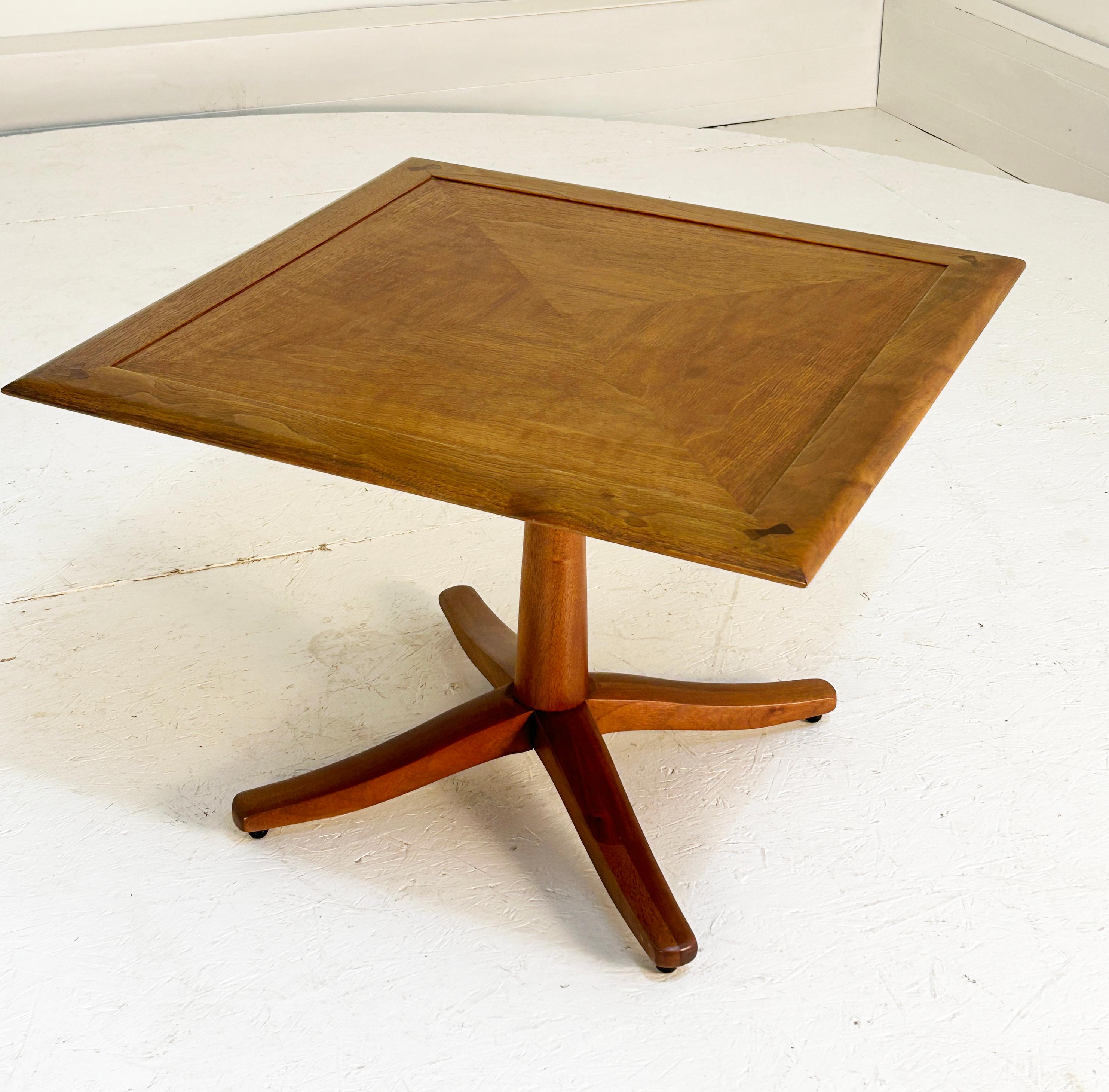 Exquisite and detailed with tapered features abound. Barney Flagg for Drexel, 1962 in Walnut and in exceptional original condition. Delicate balls suspend the table and the book matched panels are picture framed in with bowties to every corner, all