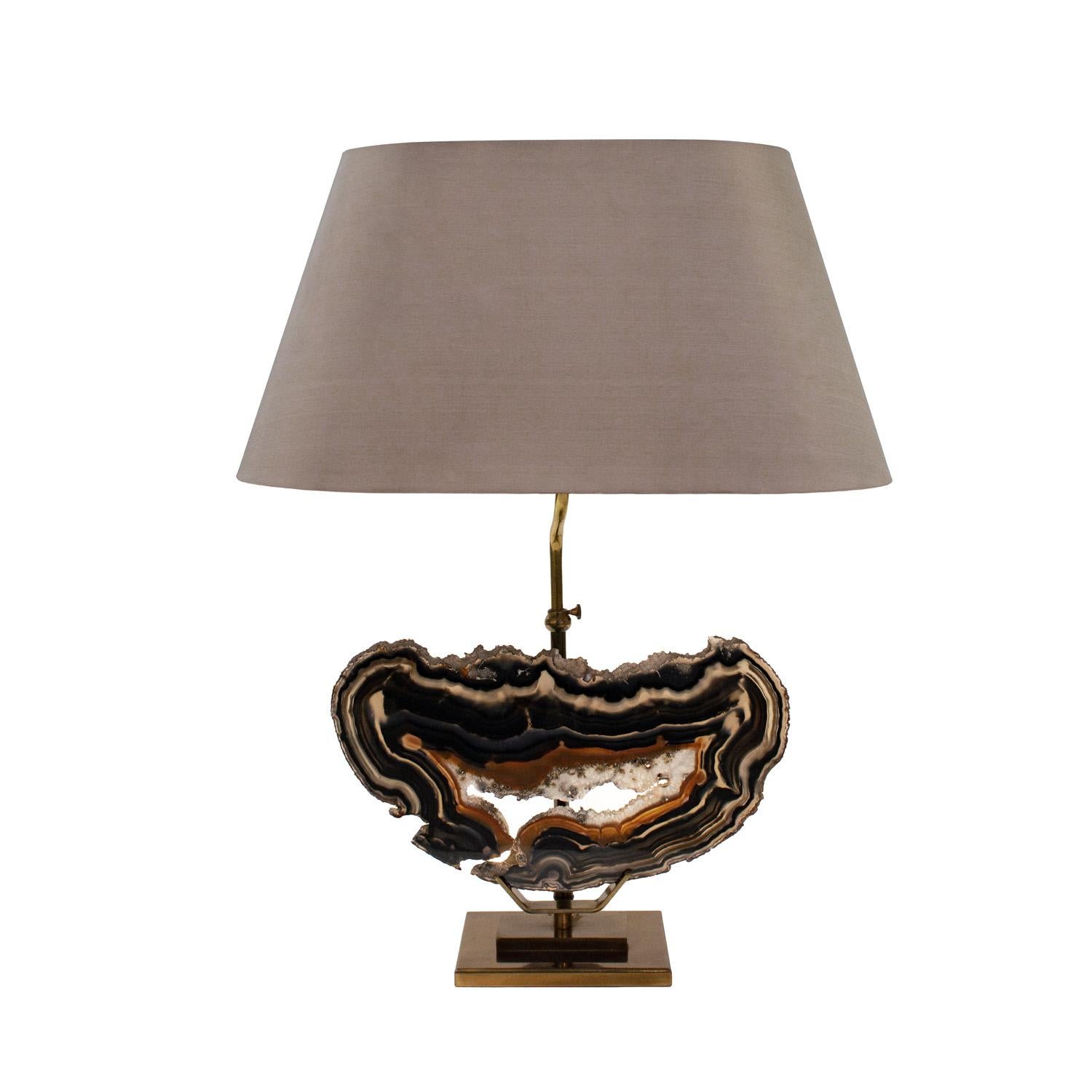 Exquisitely crafted table lamp in bronze with mounted polished agate specimen, Belgium 1970's.   The coloration of the agate, with black, beige and amber, is very chic.  This lamp has been newly rewired and comes with a silk shade with a diffuser at