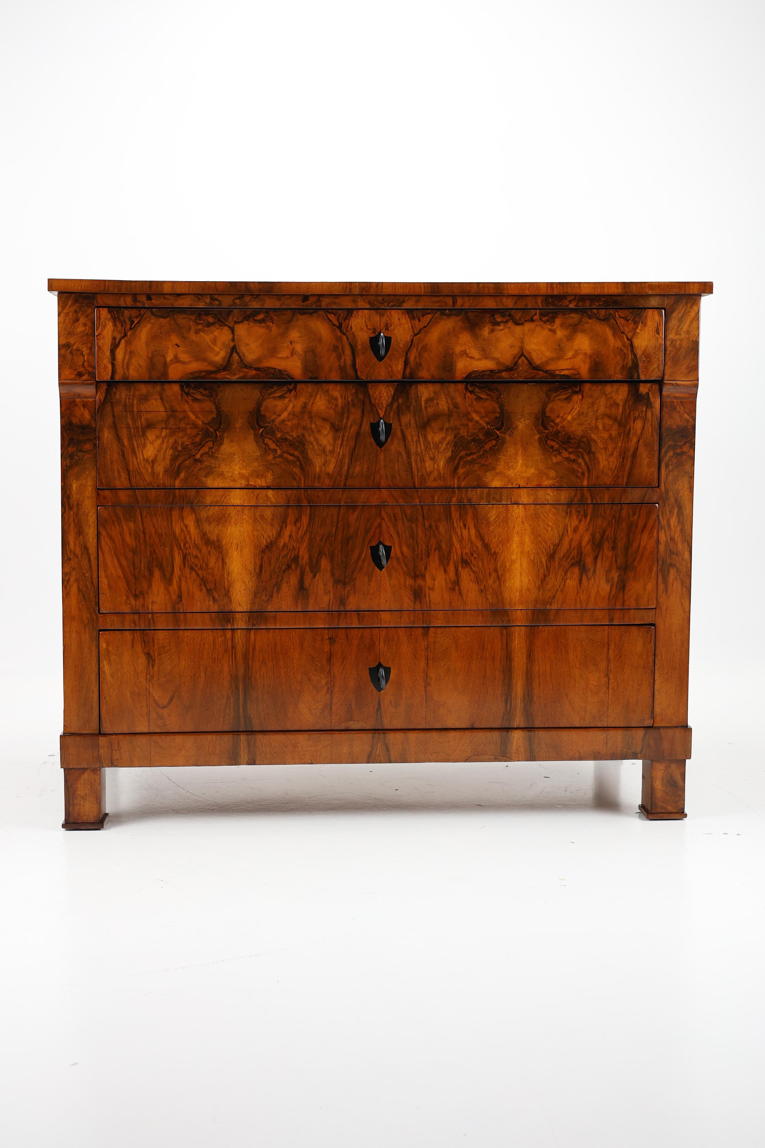 Exquisite Biedermeier Commode, Circa 1820

This exceptional commode, dating from approximately 1820, exemplifies the refined elegance of the Biedermeier period. Its most striking feature is the stunning walnut veneer, which graces the entire front