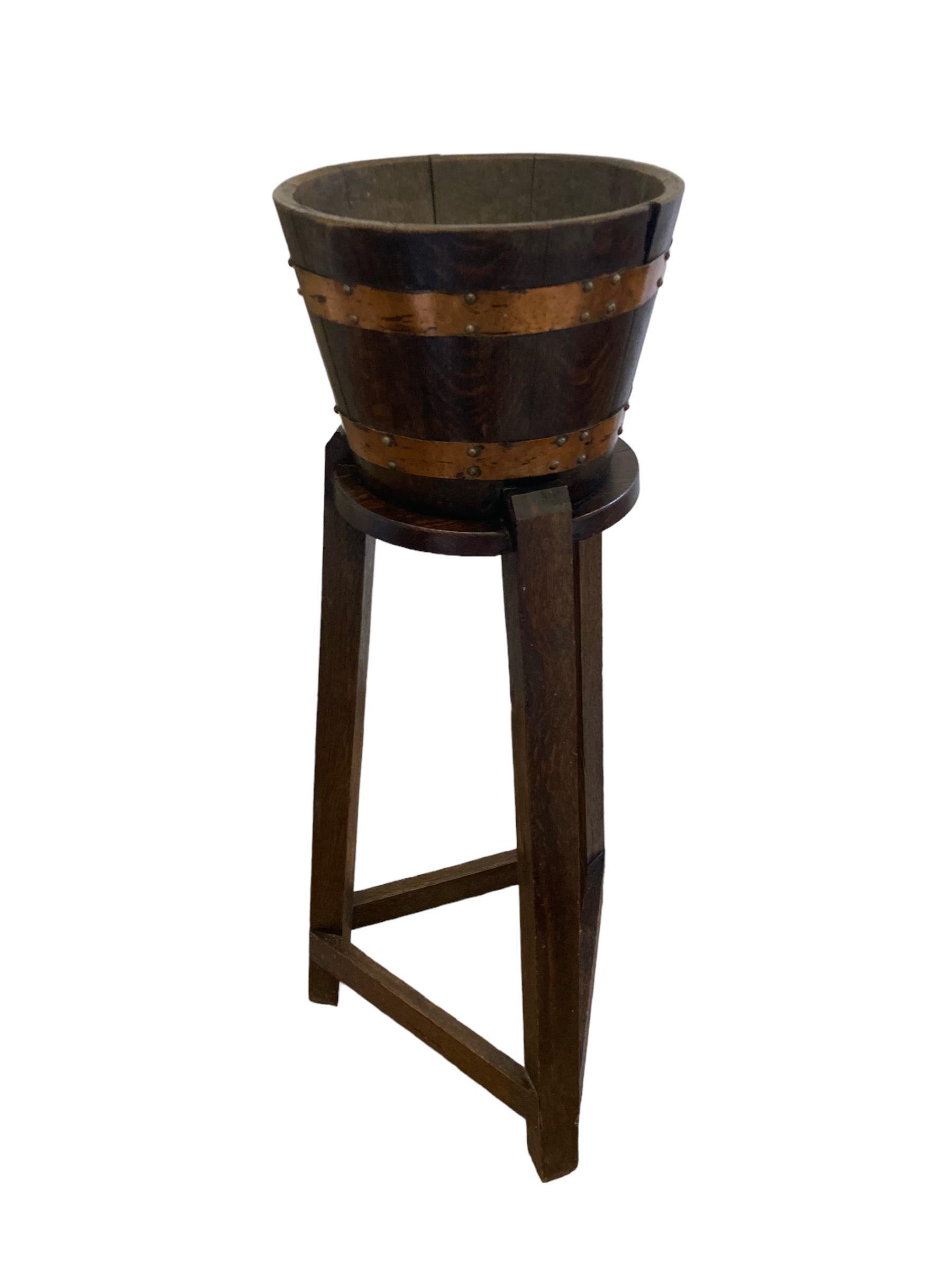 An exquisite brass bound oak jardinieres / plant stand made in a barrel construction standing on square legs. Made around the turn of the 20th century in an arts and Crafts style, these tubs were often constructed using the timber from old ships. A