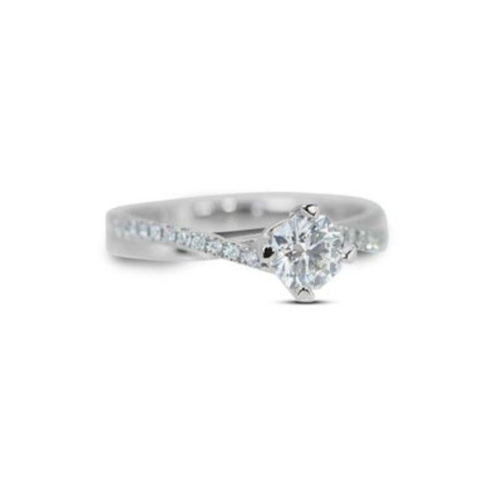 This captivating ring is a symphony of light and elegance. The centerpiece is a mesmerizing 0.7 carat round brilliant natural diamond, boasting exceptional D color and VVS1 clarity. Its brilliance dances with every movement, capturing every gaze.