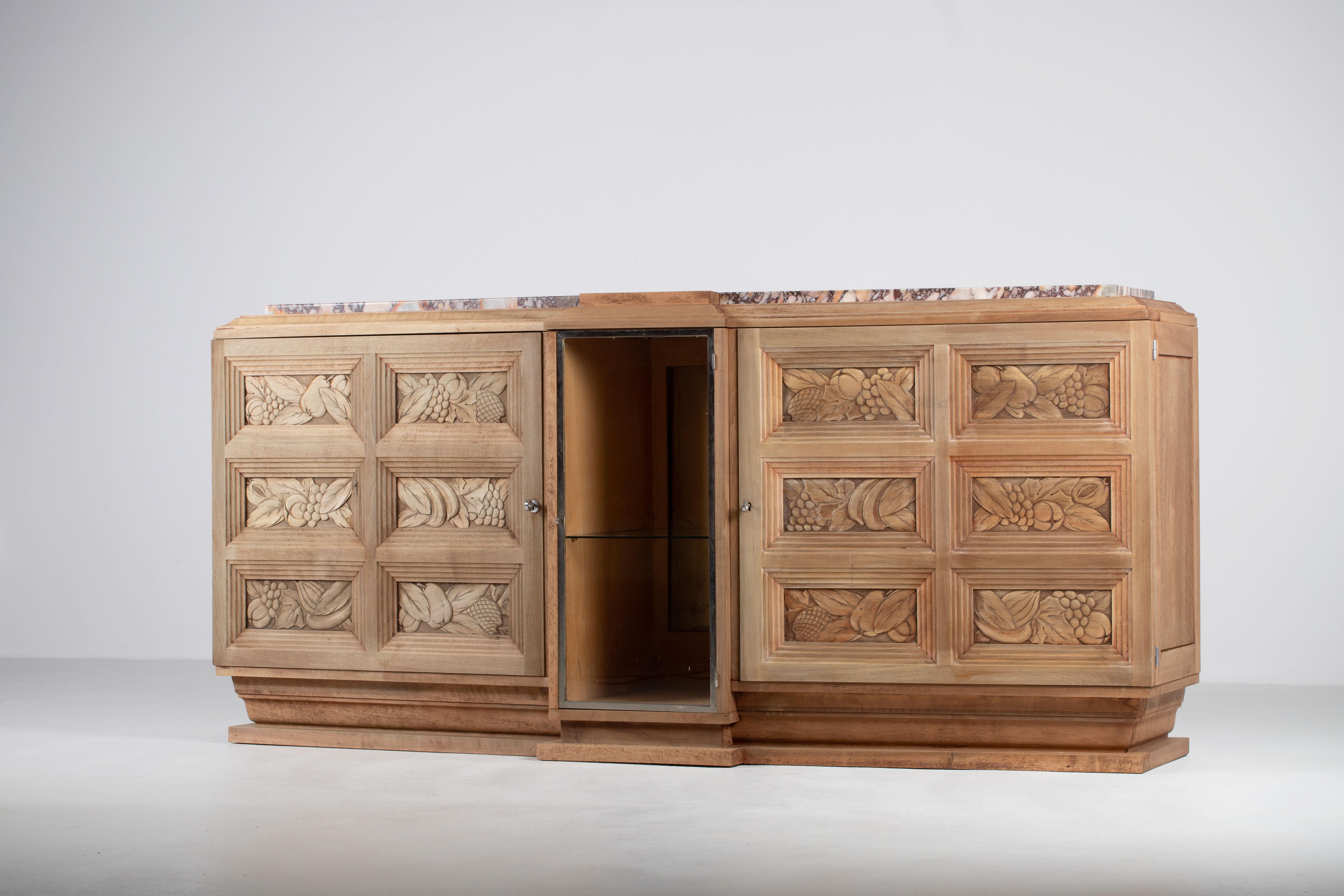 Questa credenza francese, uno studio di moderazione architettonica, distilla la chiarezza del design degli anni '40 in un gesto singolare di forza tranquilla e ornamento discreto. Realizzata in legno massiccio di quercia, la forma si impone per le