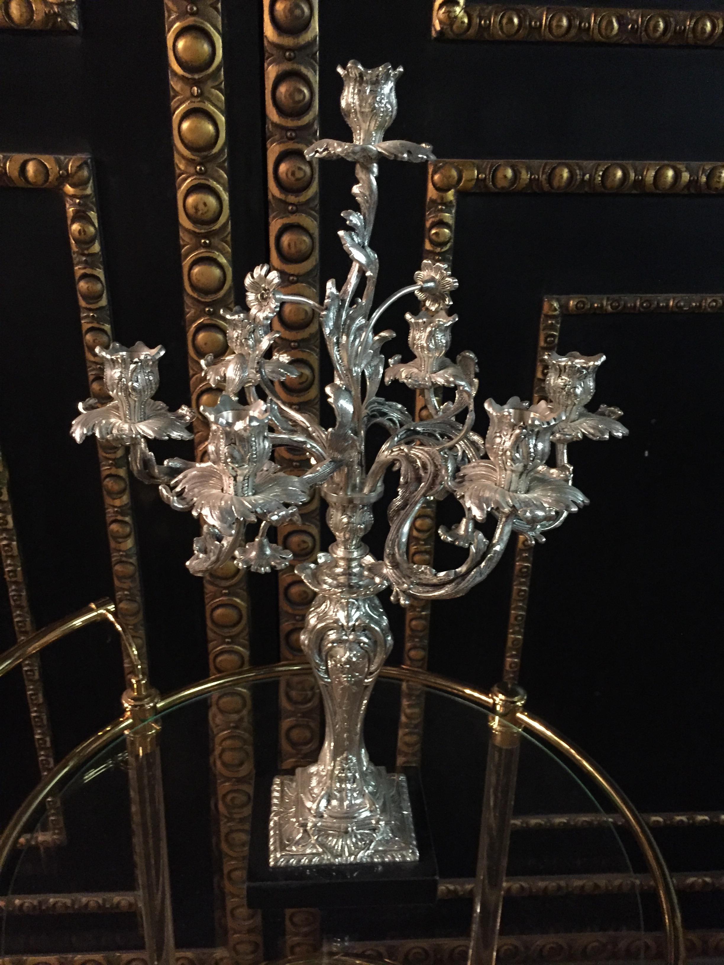 Bronze fein graviert und versilbert. Sieben geschwungene, rollende Kerzenständer
die in vasenförmigen Ösen enden.