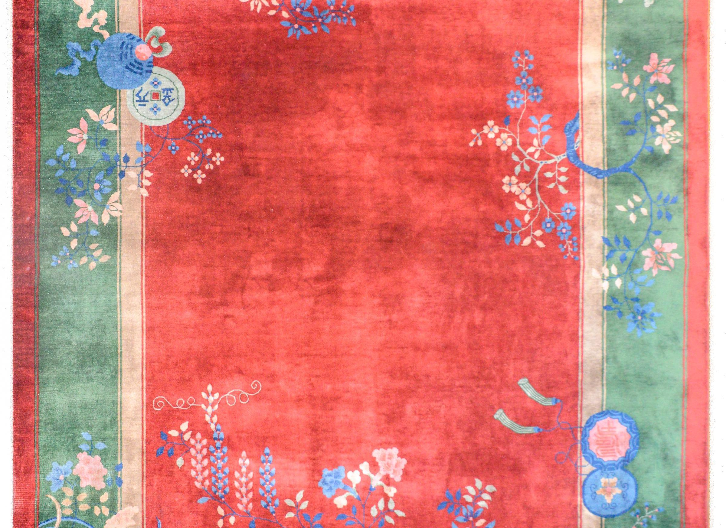 An exquisite early 20th century Chinese Art Deco rug with a rusty orange central field surrounded by a wide sage green border. Myriad auspicious flowers like chrysanthemums, peonies and cherry blossoms are overlying the field, and woven in light and