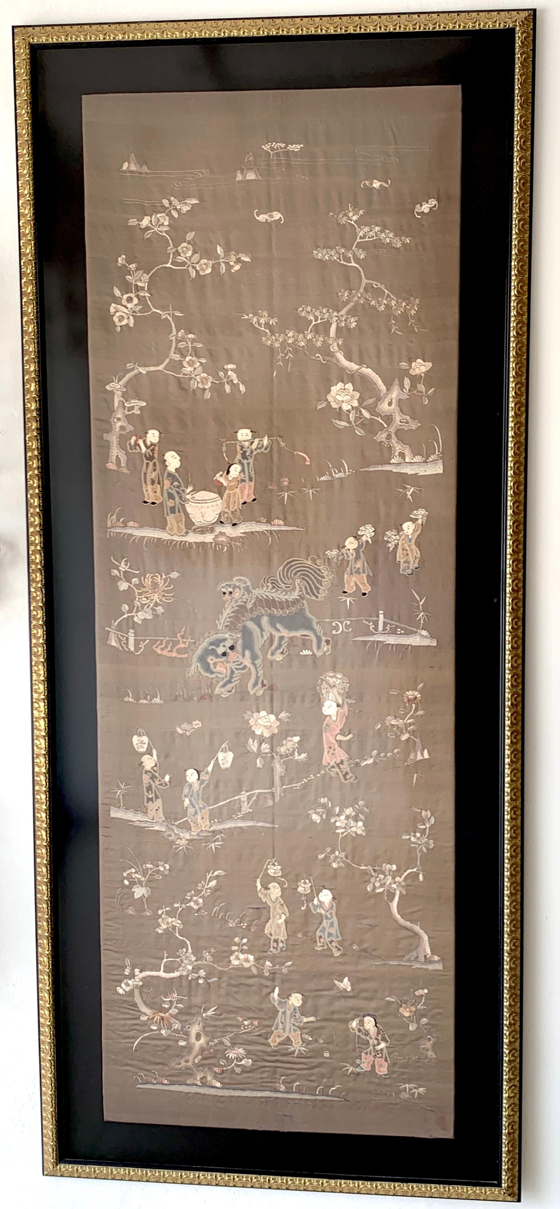 Exquisite Chinese Export landscape silk embroidery, of large size with numerous landscape vignettes with a central Foo Dog, in beautiful earth-tone palette. In a matted later frame with plexiglass front. 
The Embroidery measures 26-Inches wide x