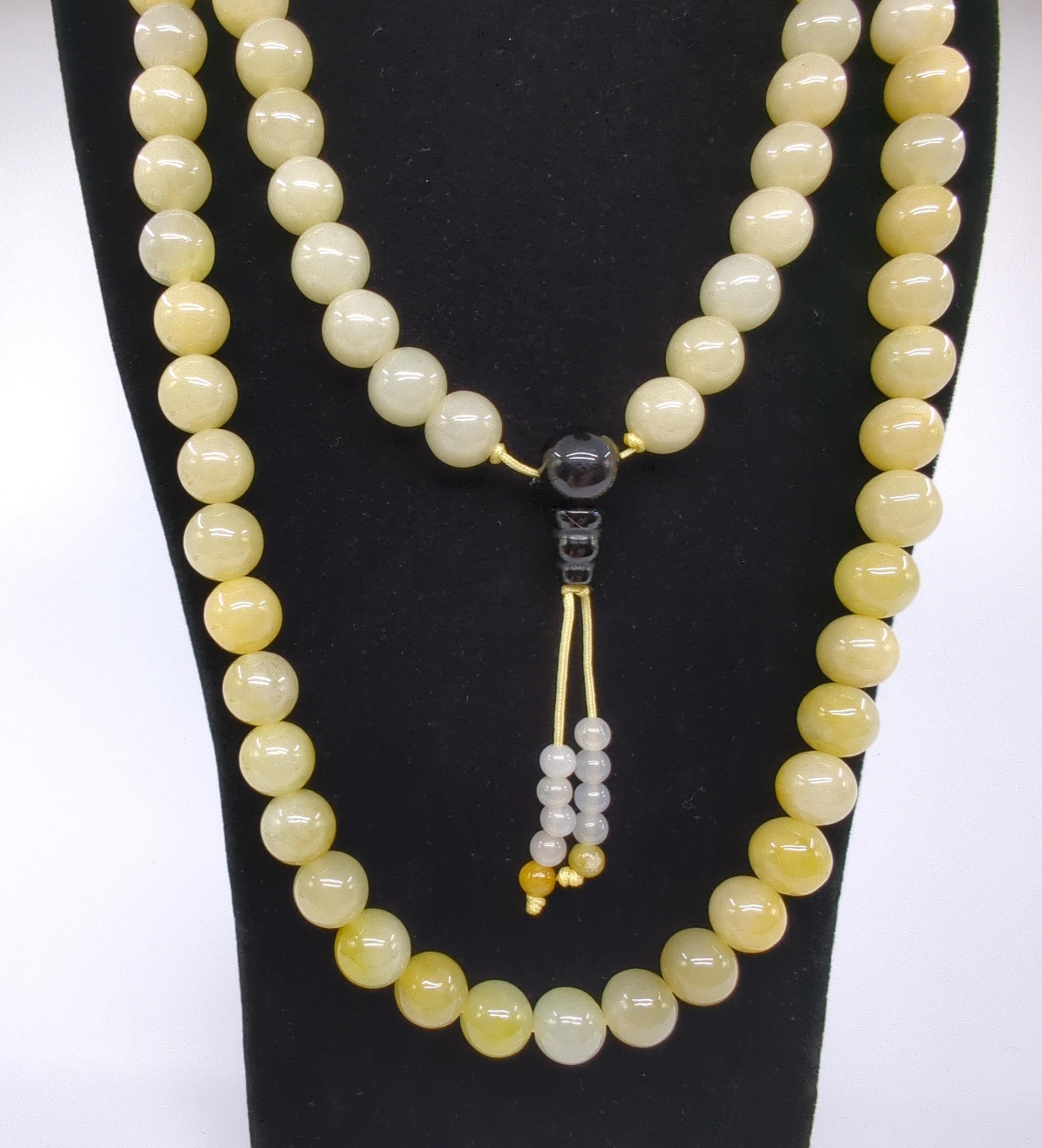 Ce magnifique collier de perles de prière chinoises est un exemple d'art et de résonance spirituelle. Il comprend 108 perles de jadéite de qualité A, chacune d'un diamètre approximatif de 9,5 mm. Les perles sont polies de manière experte pour