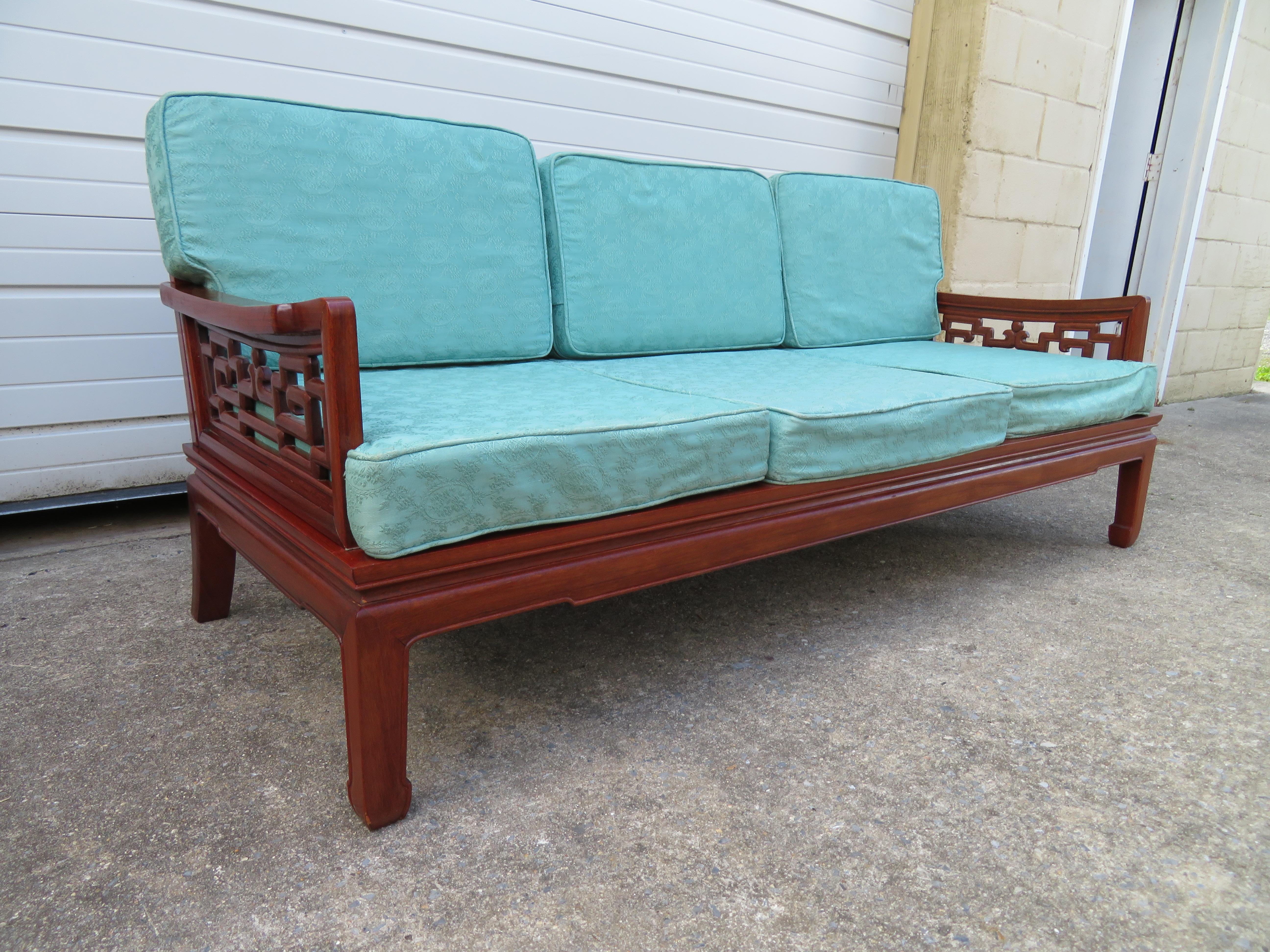 Exquisite Chinese carved rosewood sofa made in the classic Ming style. Featuring a geometric carved back and arms and chow legs. The seat pads are original and are still comfortable-re-upholstery is recommended.