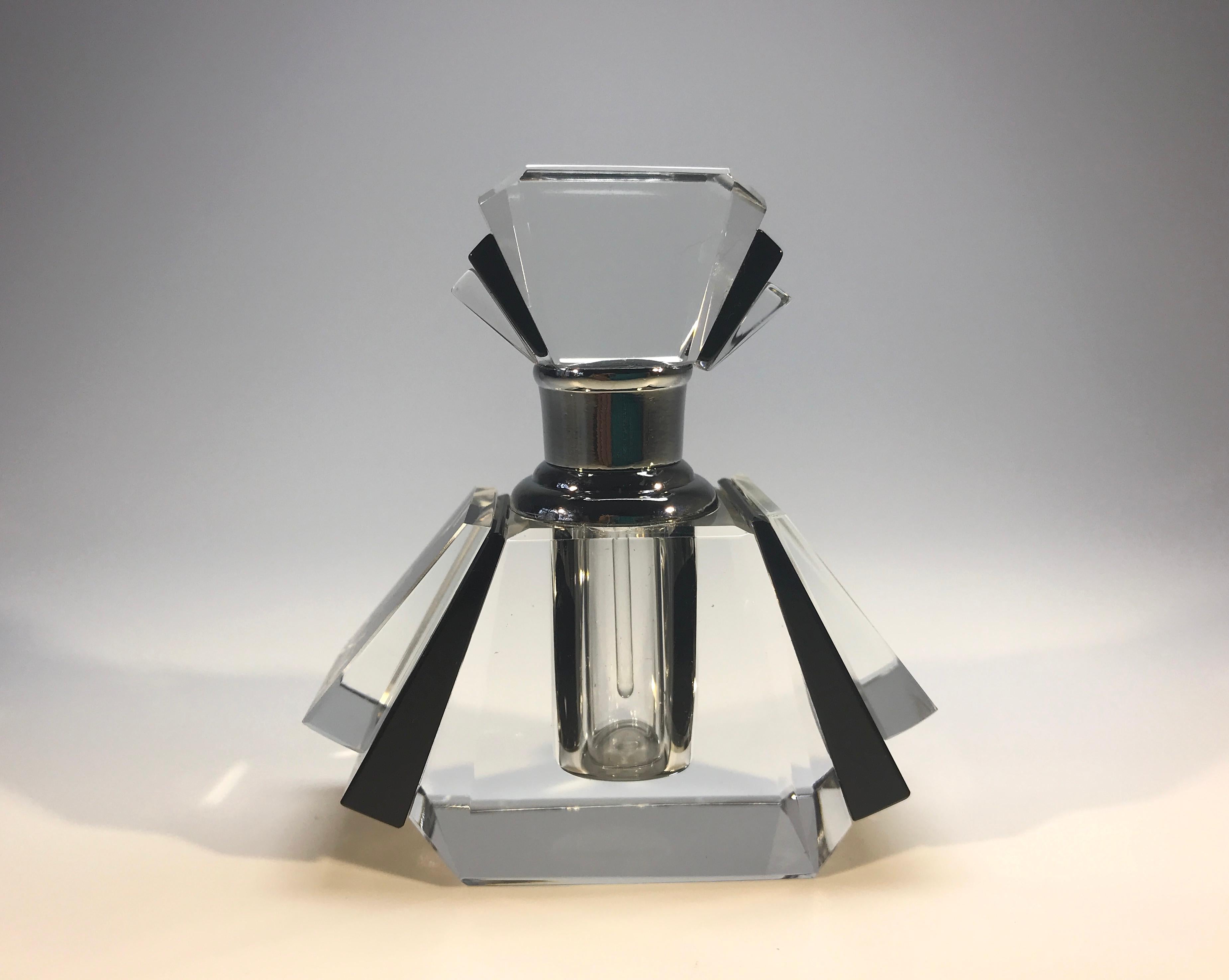 Diminutive Classic crystal perfume bottle in true Art Deco style
Geometric fan shaped clear crystal and black opaque glass
Silver colored collar. The glass pipet scent rod is in perfect condition
circa early 21st century
Measures: Height 3 inch,