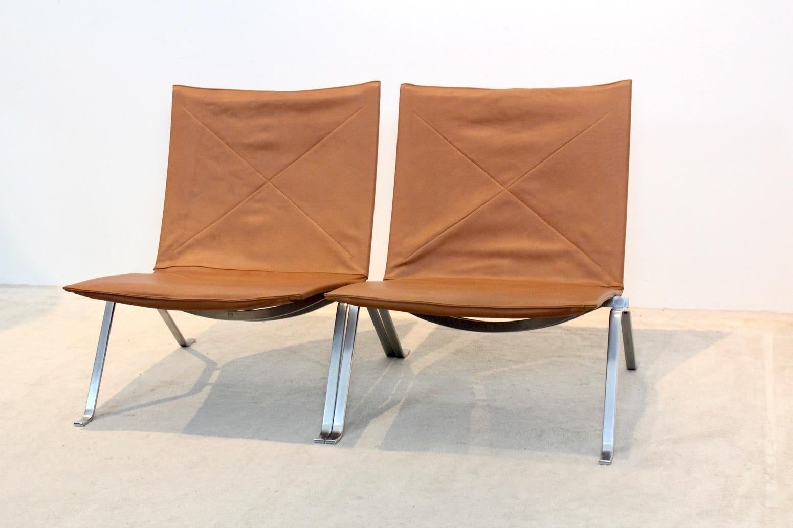 A very nice set of original PK 22 chairs designed by Poul Kjærholm for E. Kold Christensen, Denmark . This original old 1950s edition is professionally reupholstered with soft cognac leather. The solid brushed steel frame is stamped with the EKC