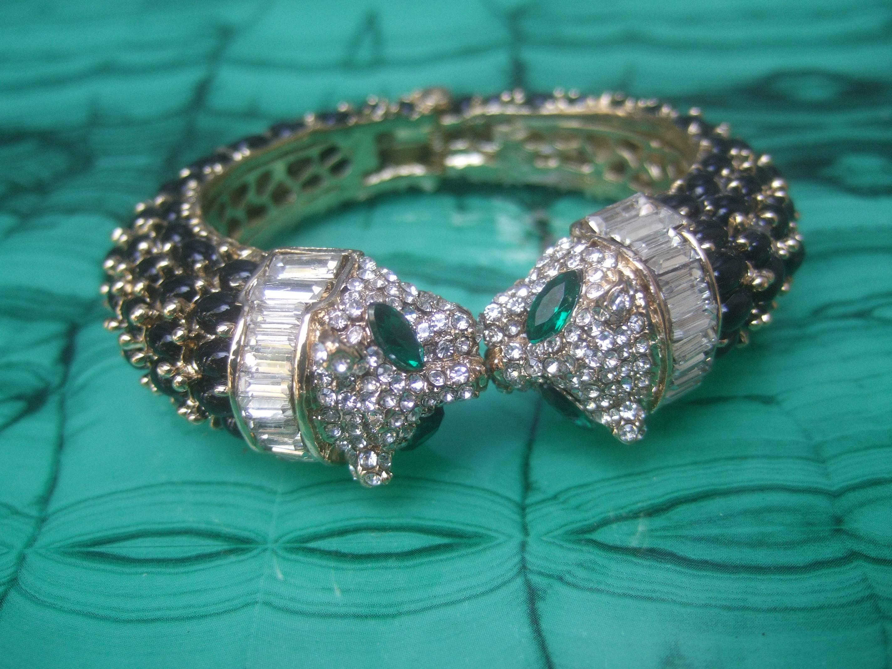 Exquisite crystal & glass jeweled panther bracelet 
The exotic hinged feline bracelet is encrusted
with rows of ebony glass cabochons on the sides

The panther's head is embellished with emerald
green color crystals with glittering pave accents
The