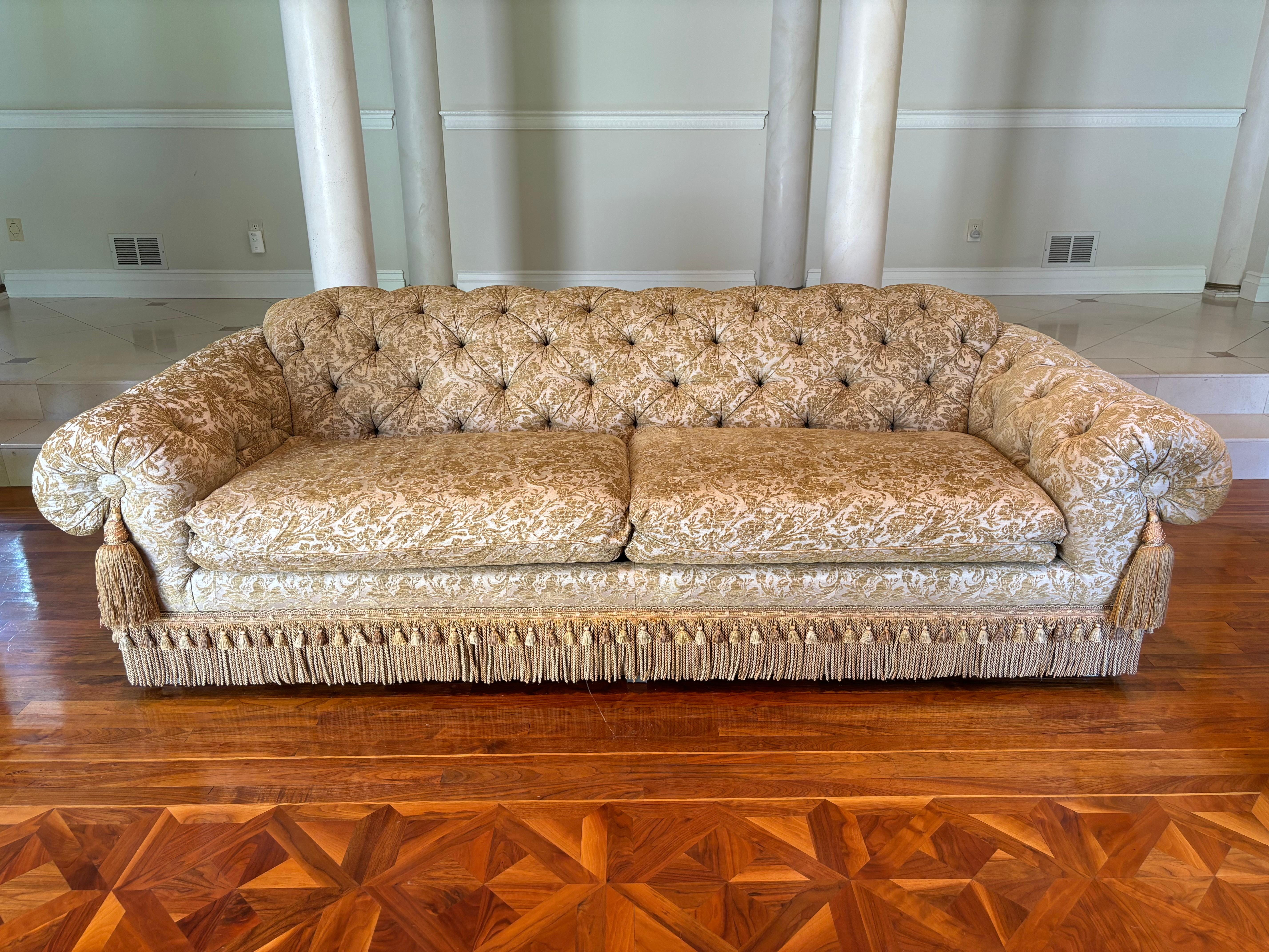 Un exquis canapé touffeté sur mesure avec une tapisserie d'ameublement damassée, avec une double frange bullion et tassel et de grands tassels sur l'accoudoir. Le damas est un luxueux damas beige qui respire la sophistication. Le capitonnage profond