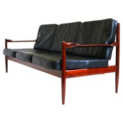 Exquis canapé 3 places Design/One danois par Grete Jalk en cuir noir et teck 1950