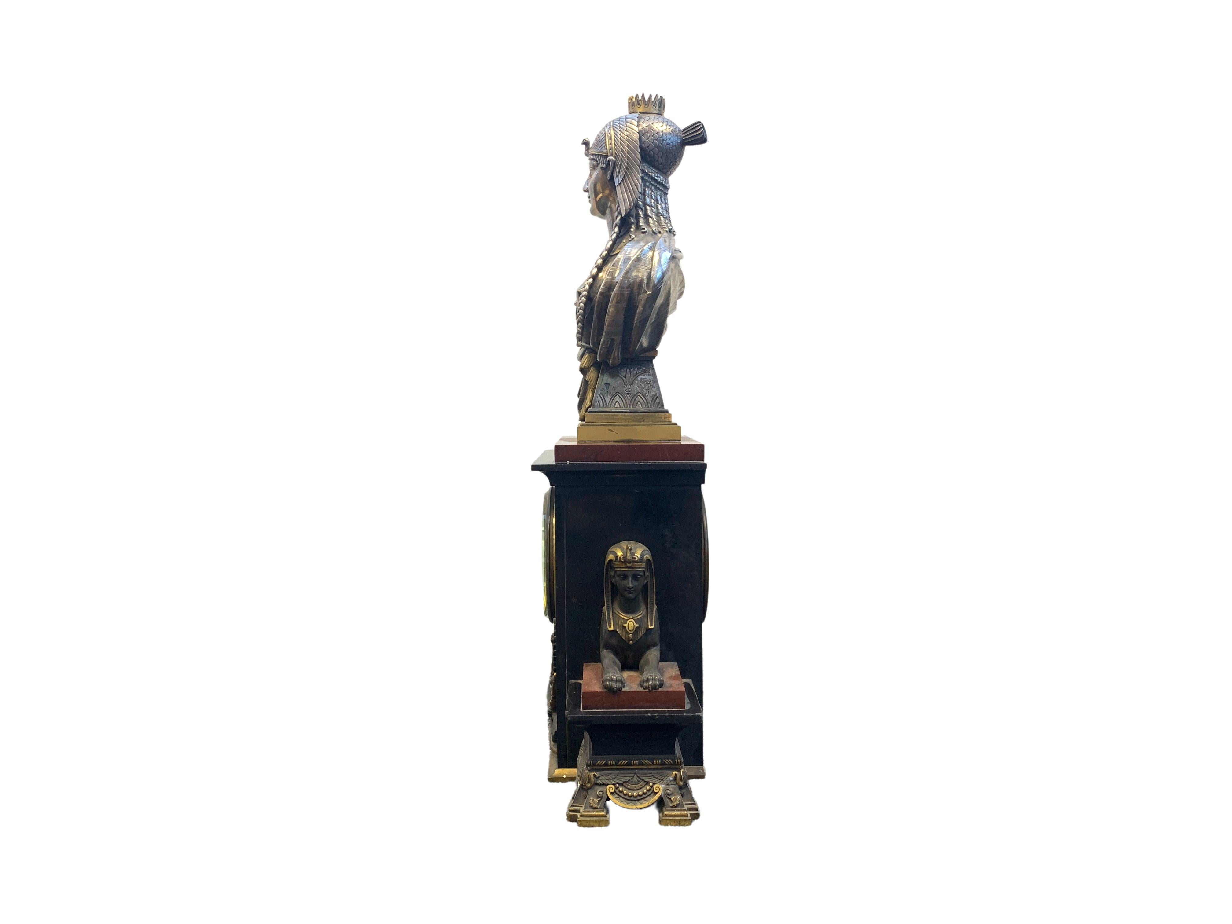 A Fine 19th century Egyptian revival clock, The Egyptian queen sits on red and black marble base with Sphinx busts on either side.
 