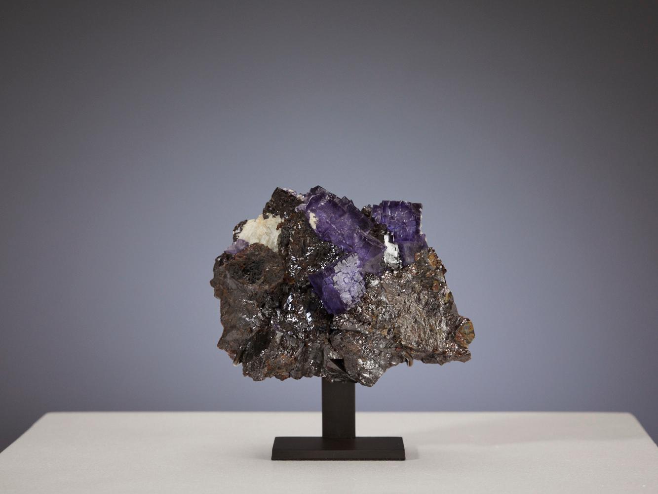 This stunning piece of Fluorite with Galena, hailing from Tennessee, USA, is a magnificent addition to any collection. Its rich purple hues, accented by the metallic sheen of Galena, create a striking contrast that is sure to captivate the eye. The