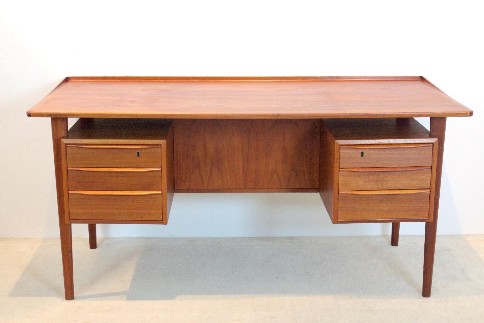 Exquisite Danish free-standing desk in teak. Designed by Peter Løvig Nielsen and produced by Hedensted Møbelfabrik Denmark in 1970. The Desk is made of teak wood and features two sets of three drawers on each side and 2 storage compartments as well