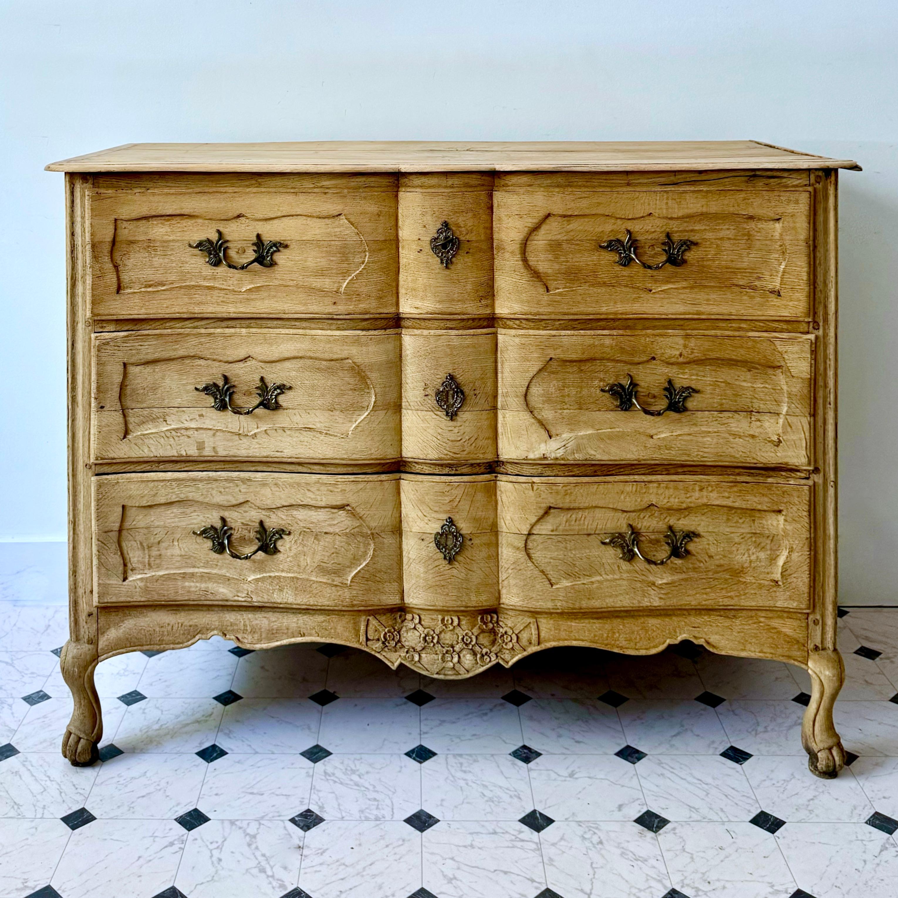 Uno squisito esemplare francese Luigi XV  commodo d'epoca in rovere sbiancato con frontali dei cassetti riccamente intagliati, grembiule intagliato in modo molto decorativo e fianchi a pannelli su corte gambe a cabriola.
1775 circa.