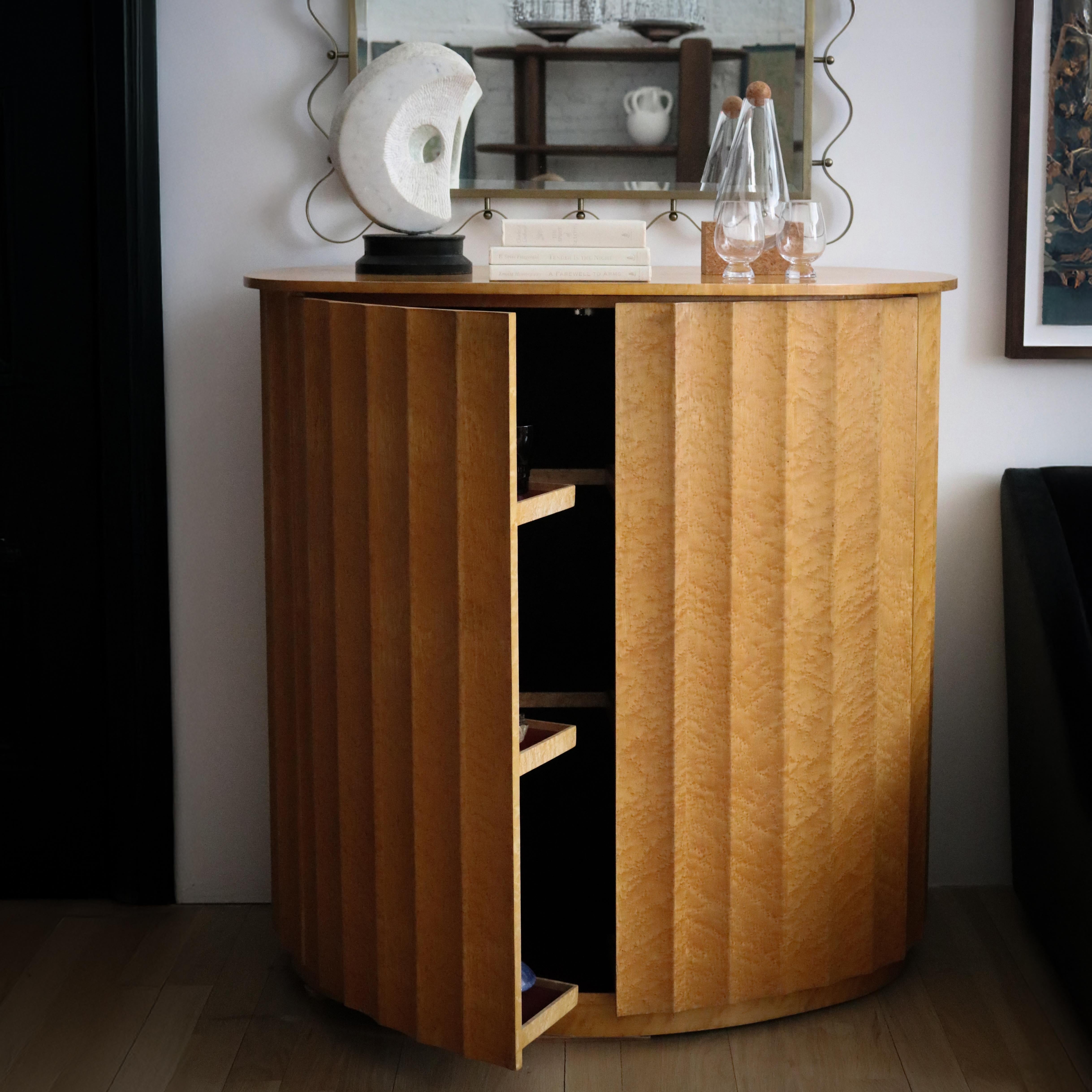 This exquisite French 1960s dry bar is a masterful expression of Art Deco transitioning into mid-century sophistication. Defined by its sculptural fluted Birds Eye façade, this piece captures the era’s fascination with architectural rhythm and