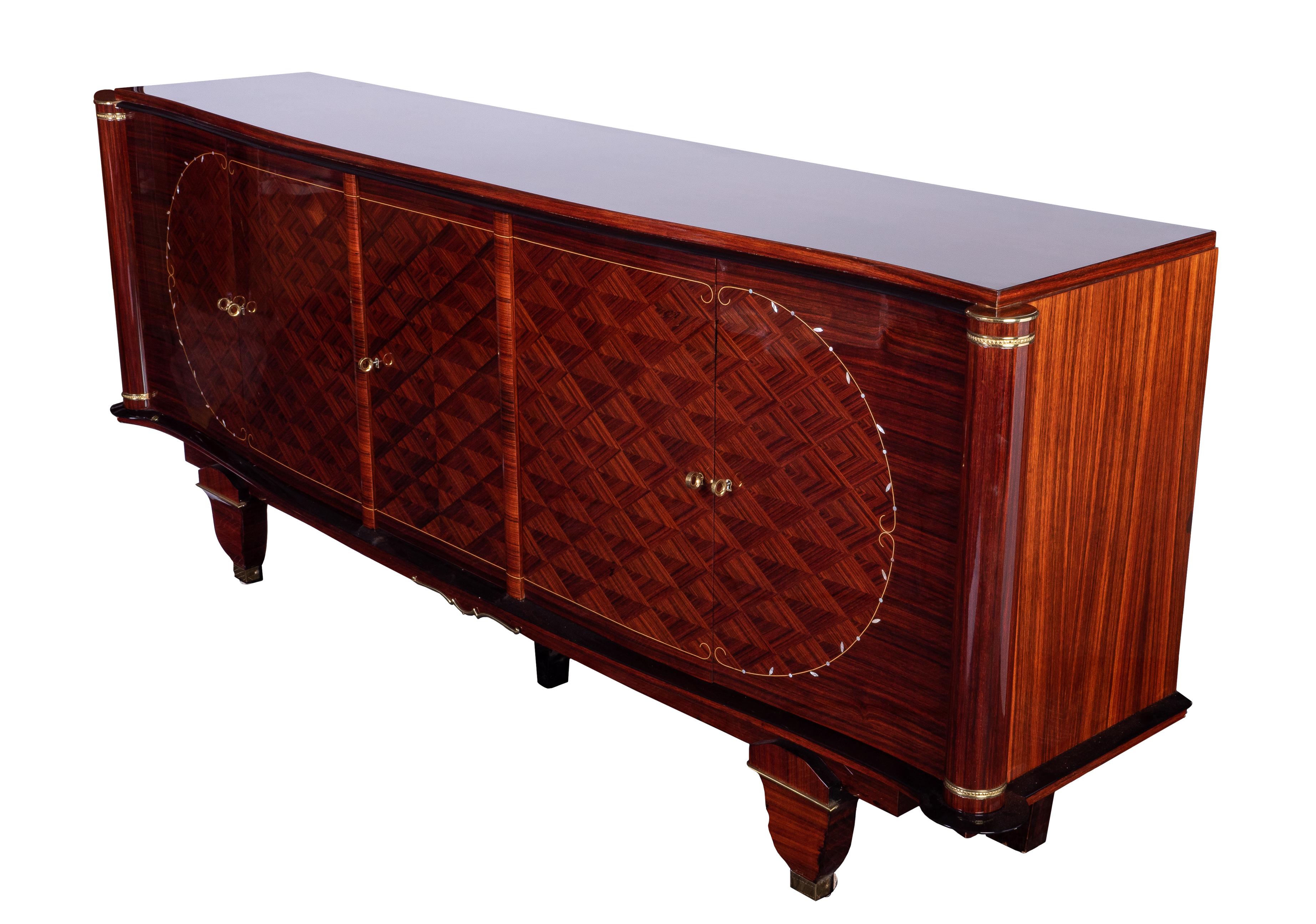 This exquisite Art Deco sideboard or credenza was designed and executed by Jules Leleu in a solid mahogany frame veneered in Indian rosewood and finished in a high gloss lacquer. It features a complicated marquetry work on the doors with a unique