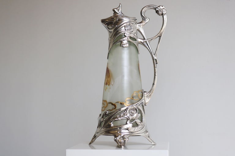 Breathtaking French antique Art Nouveau decanter / pitcher in silver plate with enamel painted glass by Jules Barian 1900. 
Exquisite Art Nouveau design and just a pleasure to look at. Amazing enamel hand painted floral decorations. 
Superb