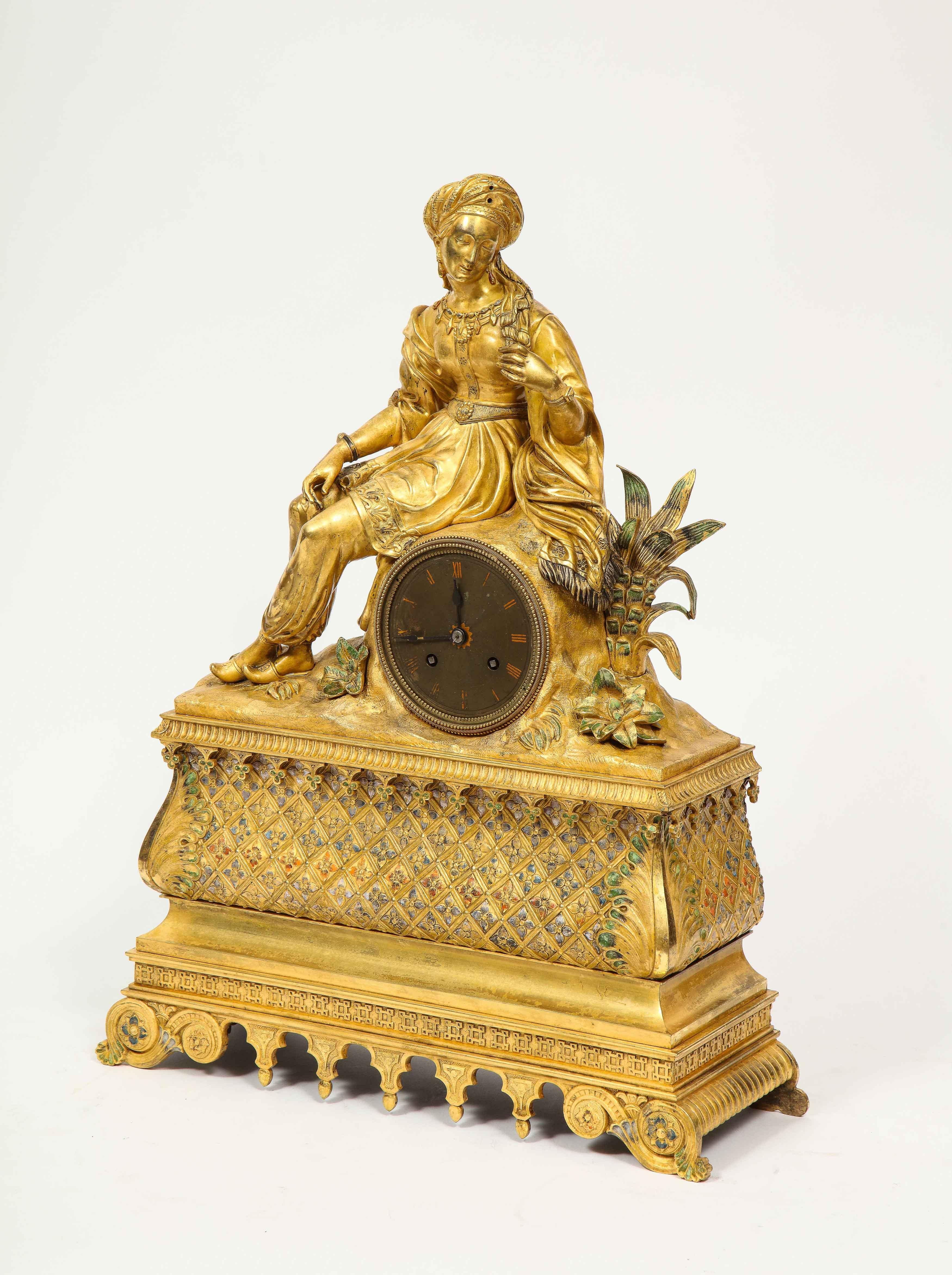 Exquisite French Charles X ormolu and enamel orientalist sultana figural table clock, early 19th century.

Depicting a seated orientalist sultana turbaned woman wearing jewelry, dressed in her elaborate garments. The clock case enameled