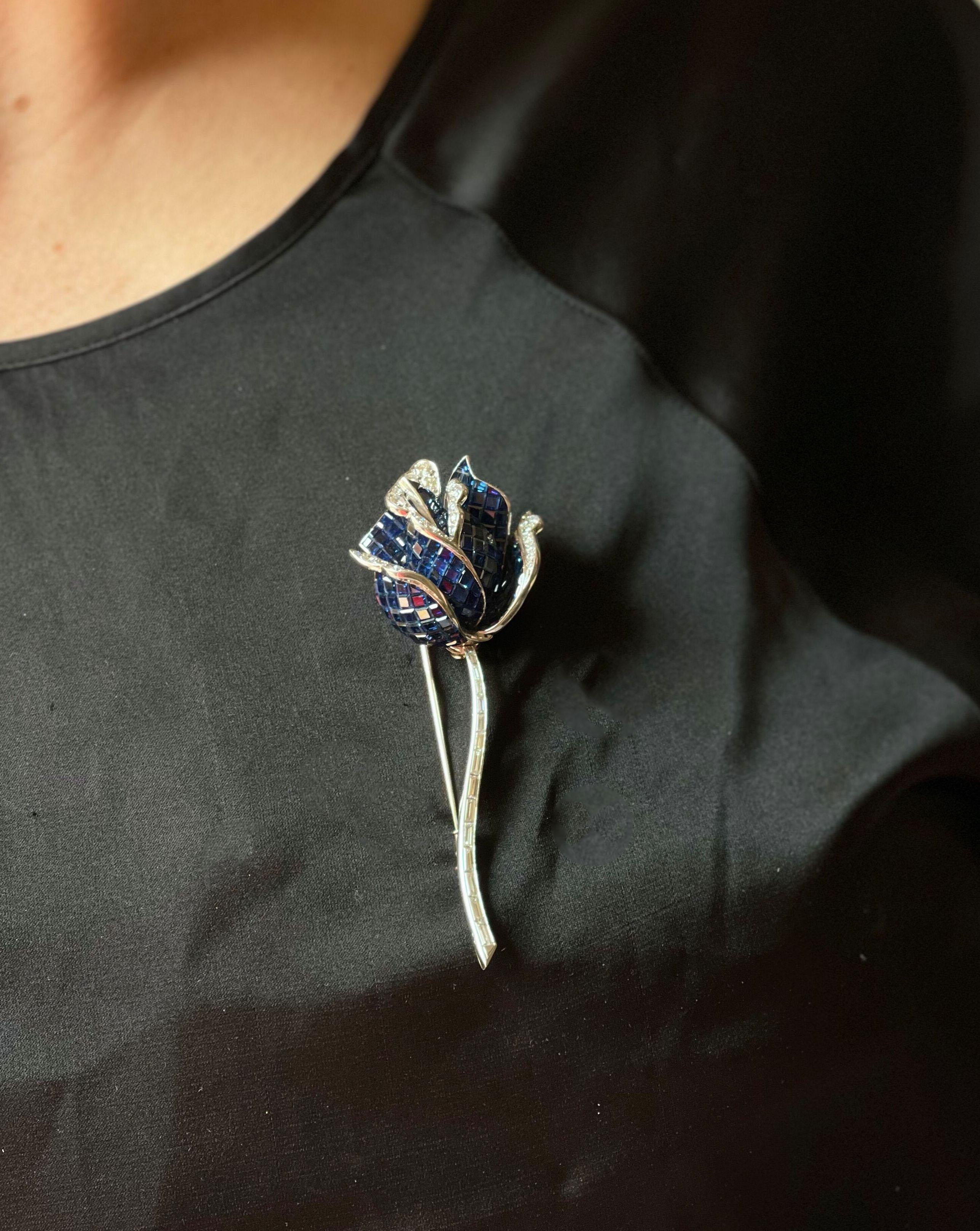 French made exquisite rose flower brooch, in 18k gold, featuring vibrant invisible set sapphires and approx. 1.00ctw G/VS diamonds. Brooch is 3.5