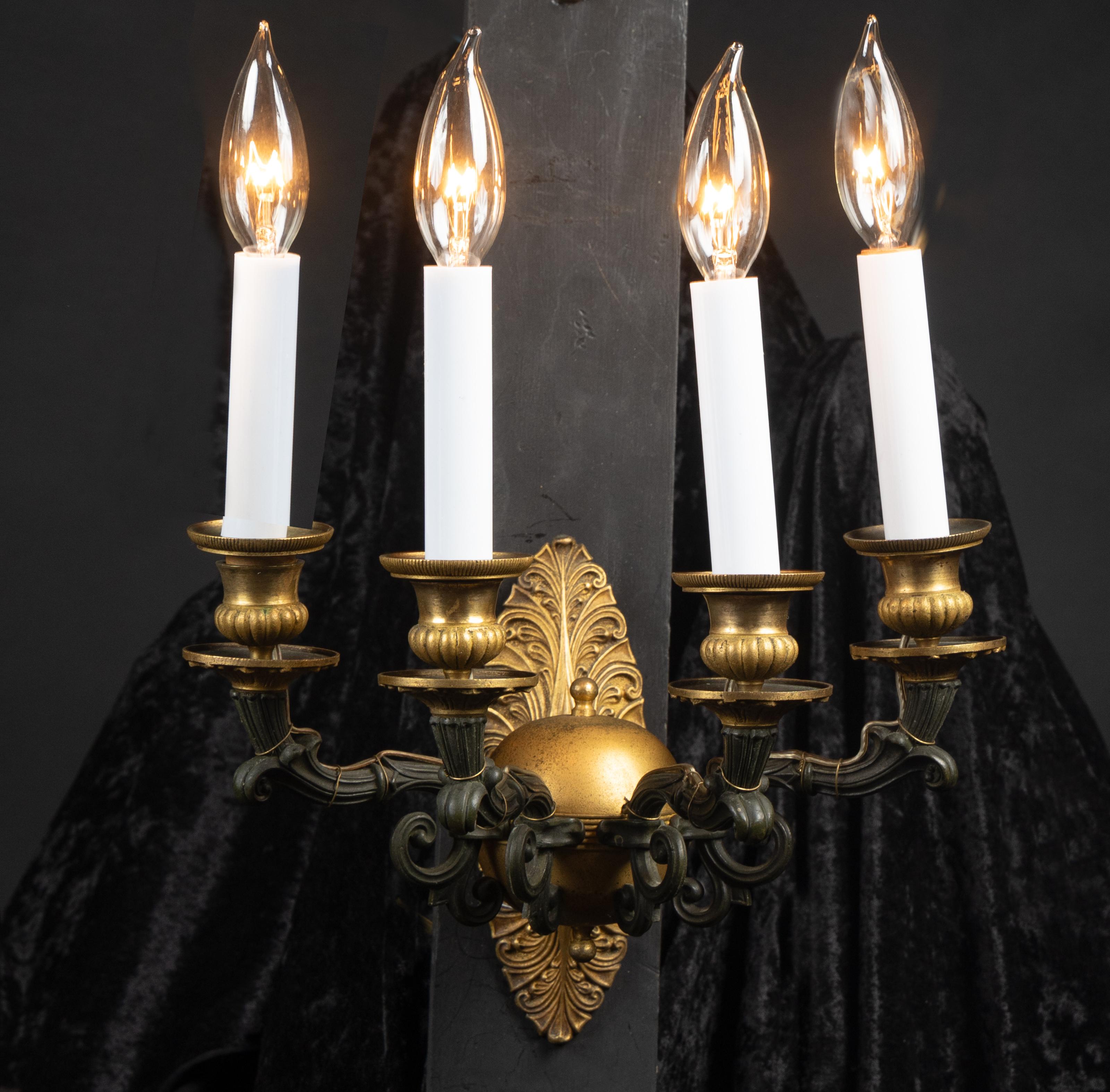 Exquisite French 19th century four-light bronze sconce with patinated bronze arms attached to large bronze orb in front of acanthus leaf backplate.  The sconces are adorned with bronze drippers, bronze candle cups in the shape of classic urns, and