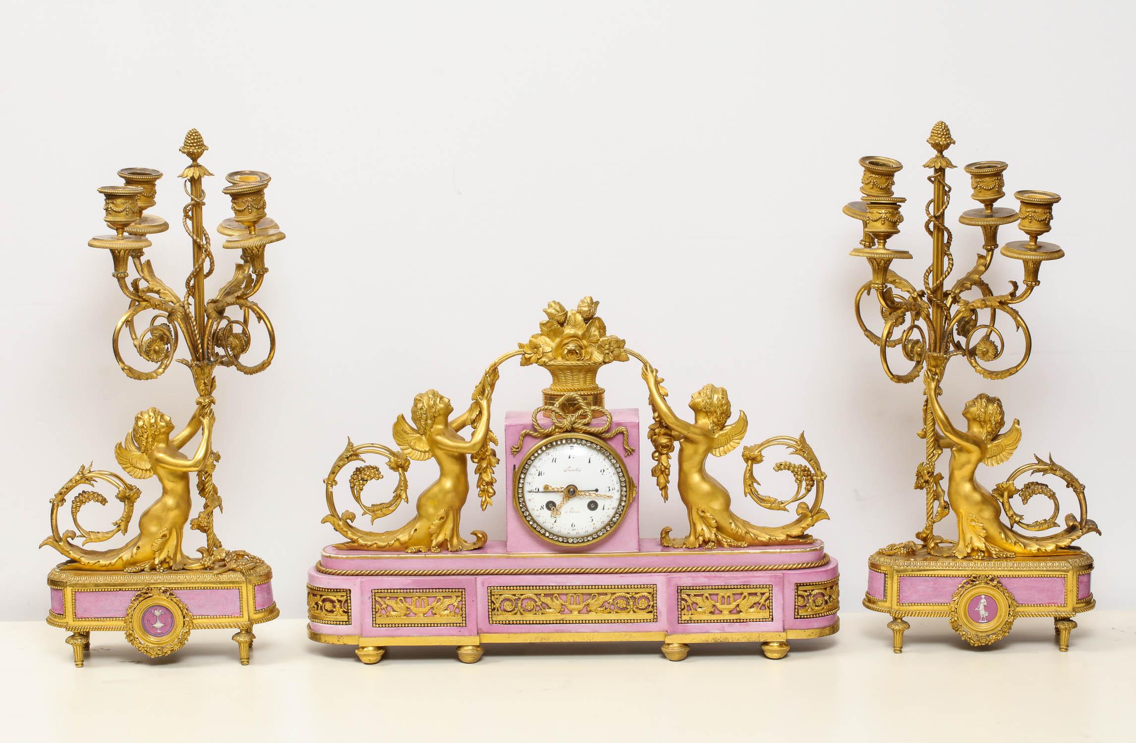 Exquisite French ormolu bronze and pink porcelain three-piece clock set garniture after Francois Remond. 

The clock by Furet A Paris. Design of the case after Francois Rémond (circa 1747-1812) French chaser, engraver, founder and gilder.

Dial