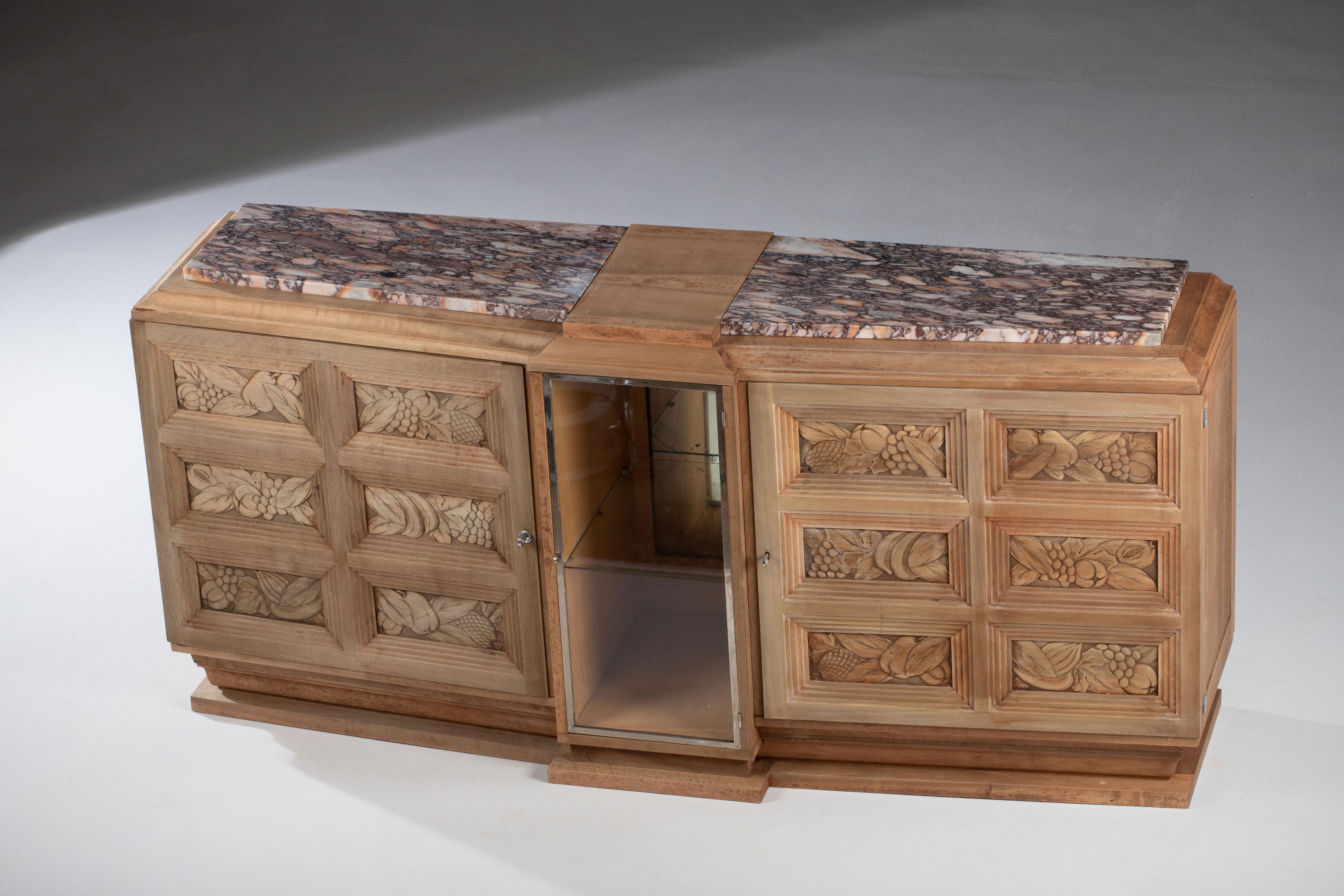 Very elegant credenza in solid oak, France, 1940s.
Art Deco Brutalist sideboard. 
The credenza consists of Two storage facilities covered with handcarved fruits designed doors and a central vitrine.


