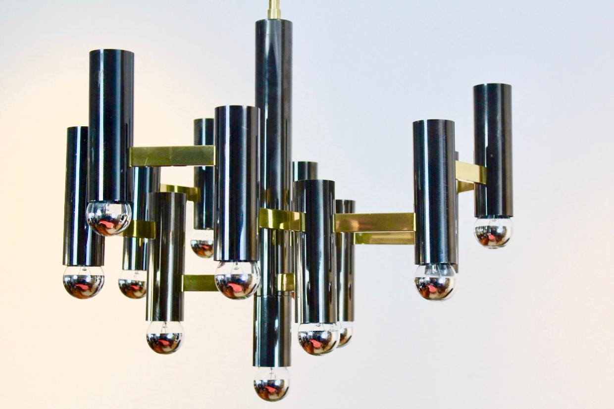 Very beautiful and rare Gaetano Sciolari chandelier in brass and the unique black pearl color. This is a large 13 bulbs chandelier hanging on a massive brass bar. Nice modernist geometric structure and with a perfect style and fantastic light