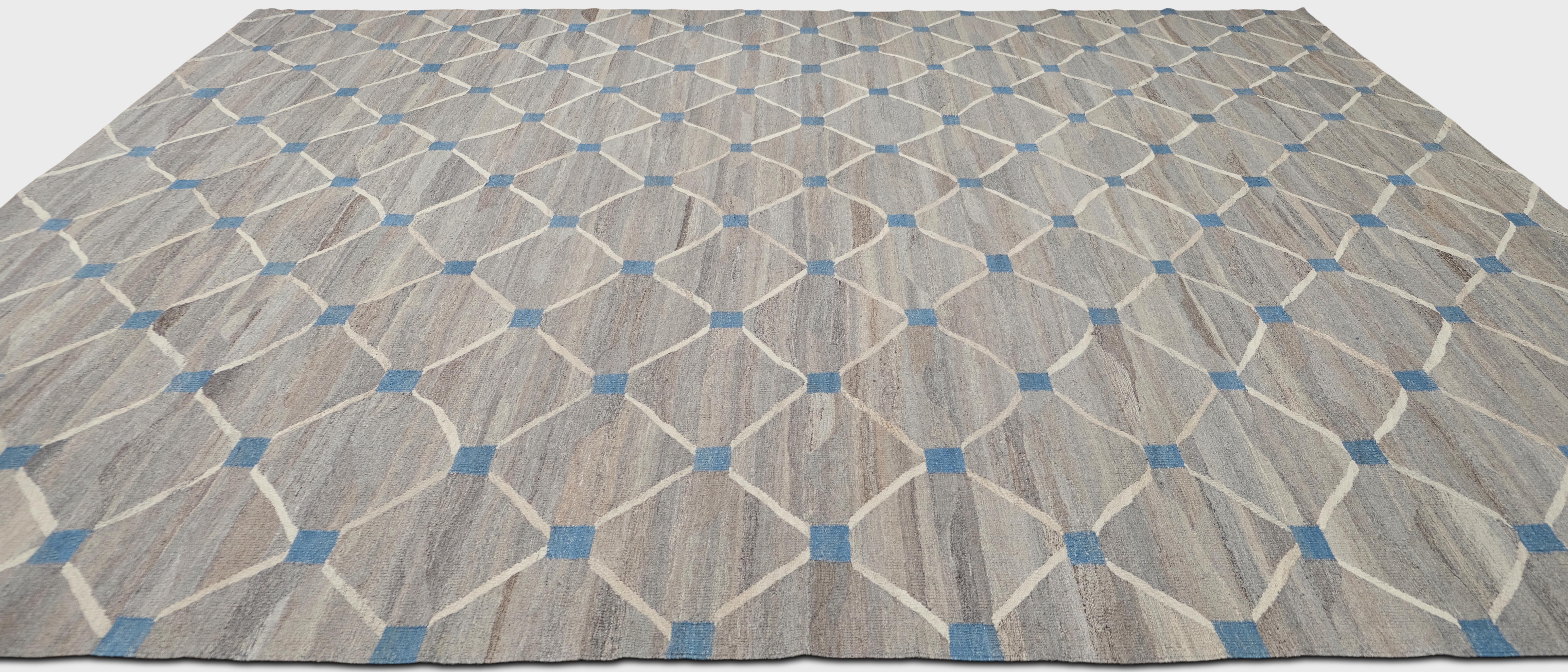 Présentant un motif géométrique complexe en treillis avec des accents bleus sur un fond neutre gris et beige, ce tapis ajoute sophistication et charme à tout espace intérieur.

Caractéristiques principales :
Origine : fabriqué à la main en